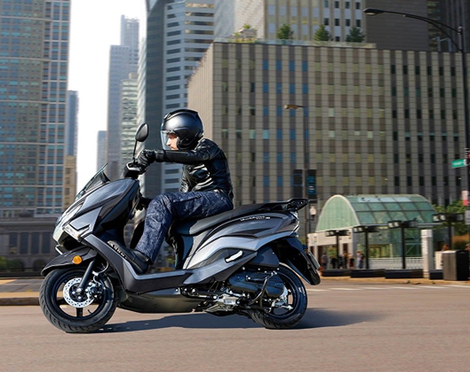 Suzuki Burgman Street 125 gris circulando por la ciudad con motociclista