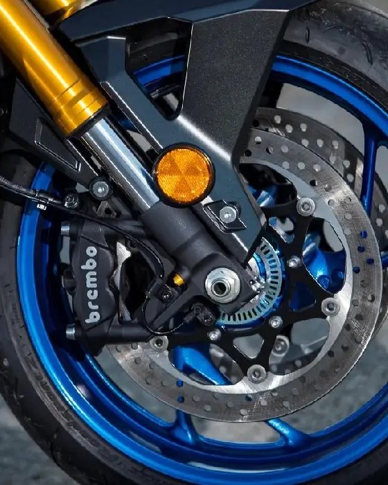 Primer plano del freno delantero Brembo de anclaje radial y horquilla telescópica invertida dorada en la Suzuki GSX-S1000