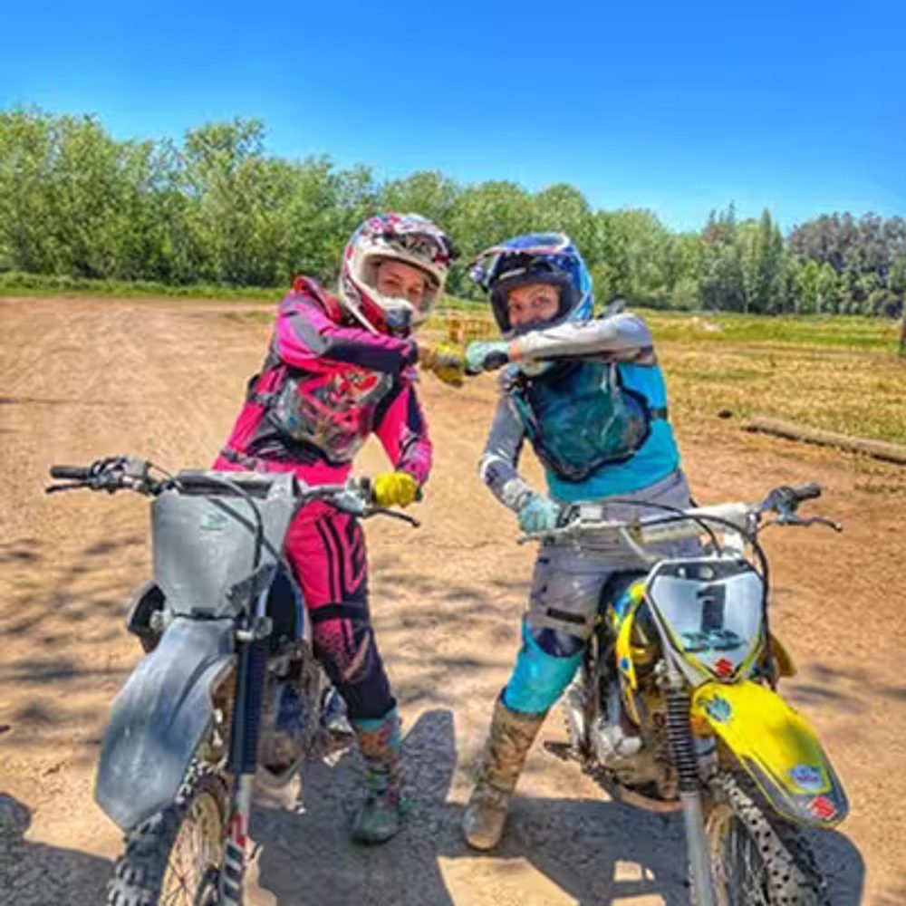 Dos personas en motocicleta chocando sus puños
