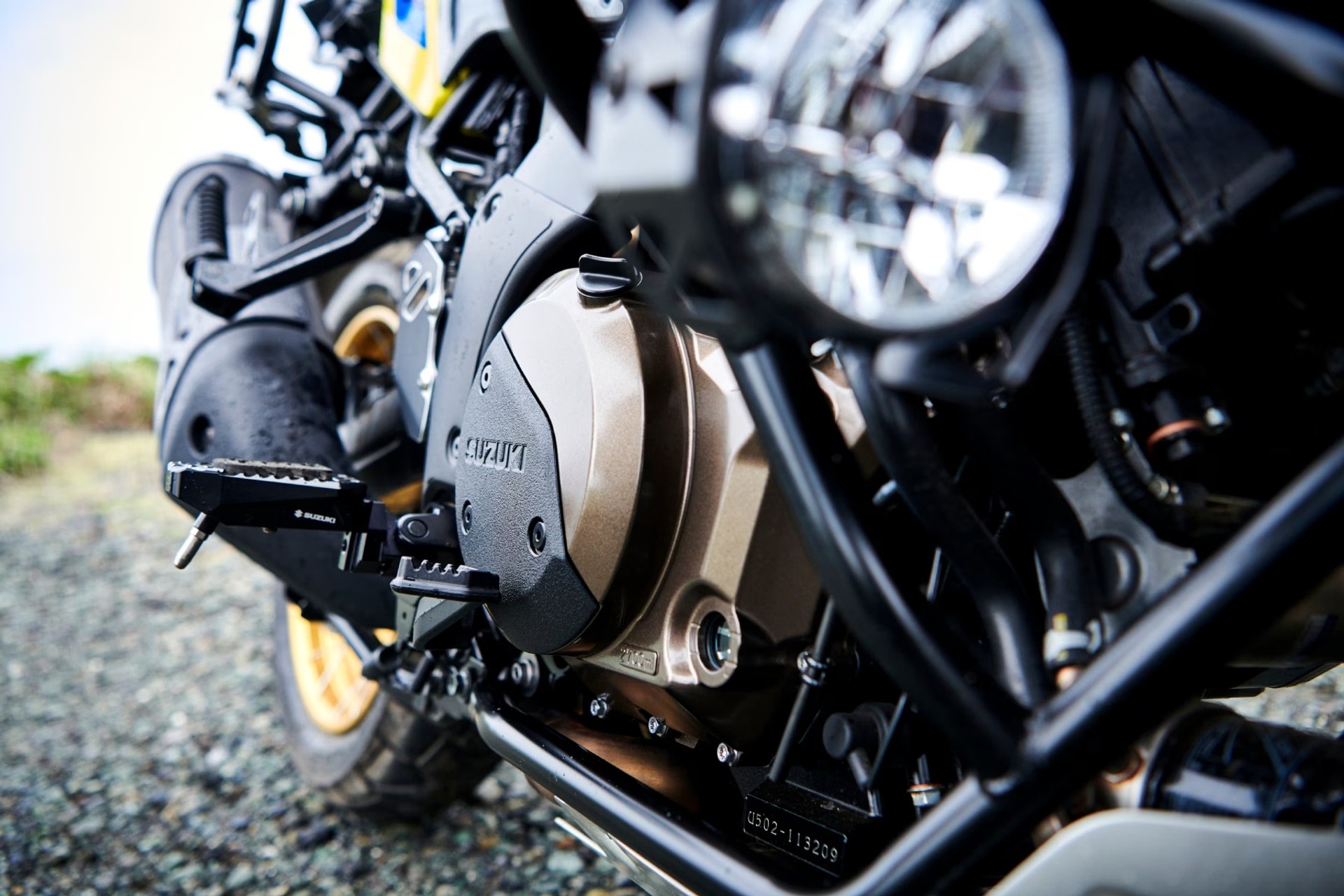 Detalle del motor V-twin de la Suzuki V-Strom 1050DE con reposapiés y defensas
