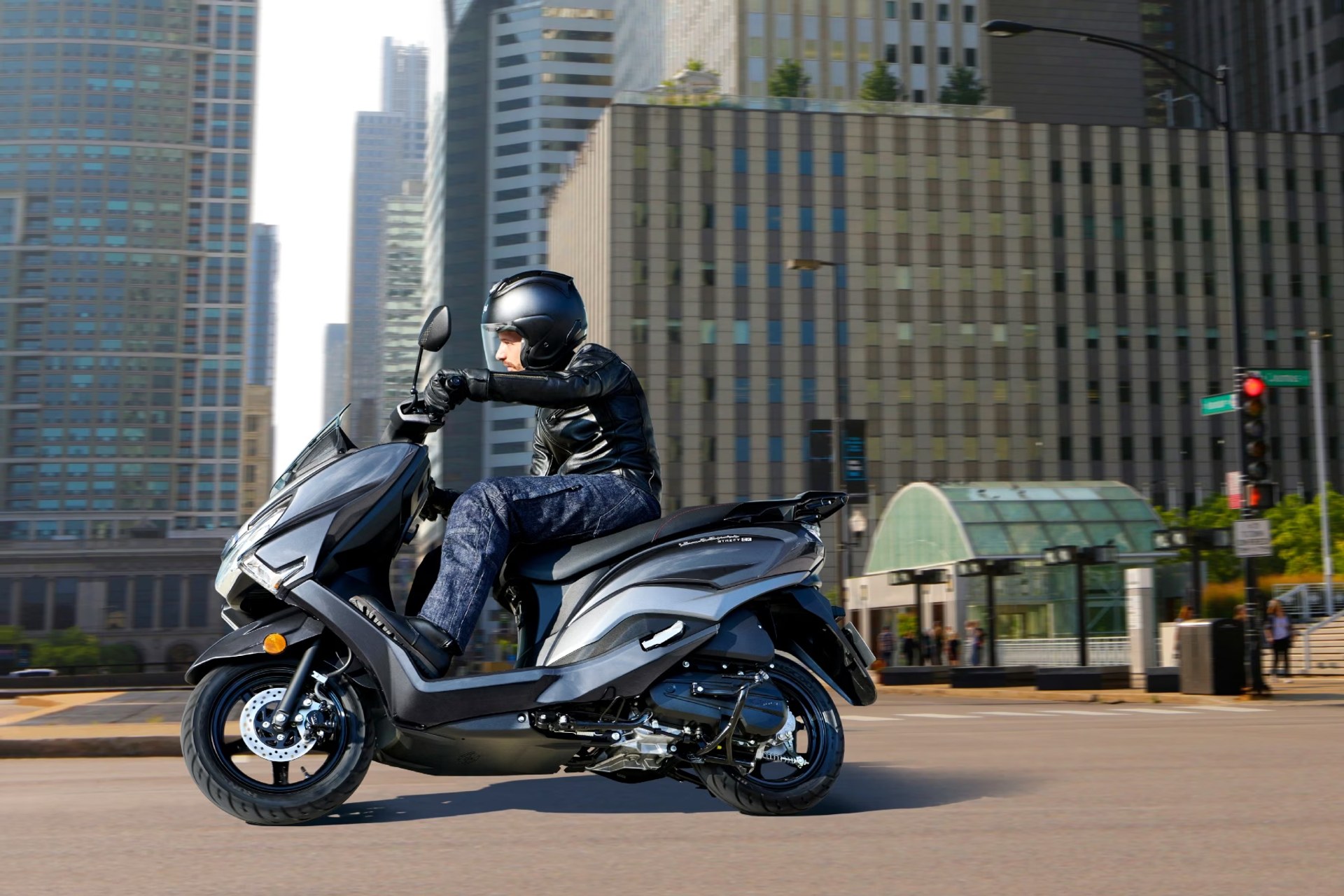 Vista de perfil de un piloto conduciendo el scooter Suzuki Burgman Street 125EX por la ciudad