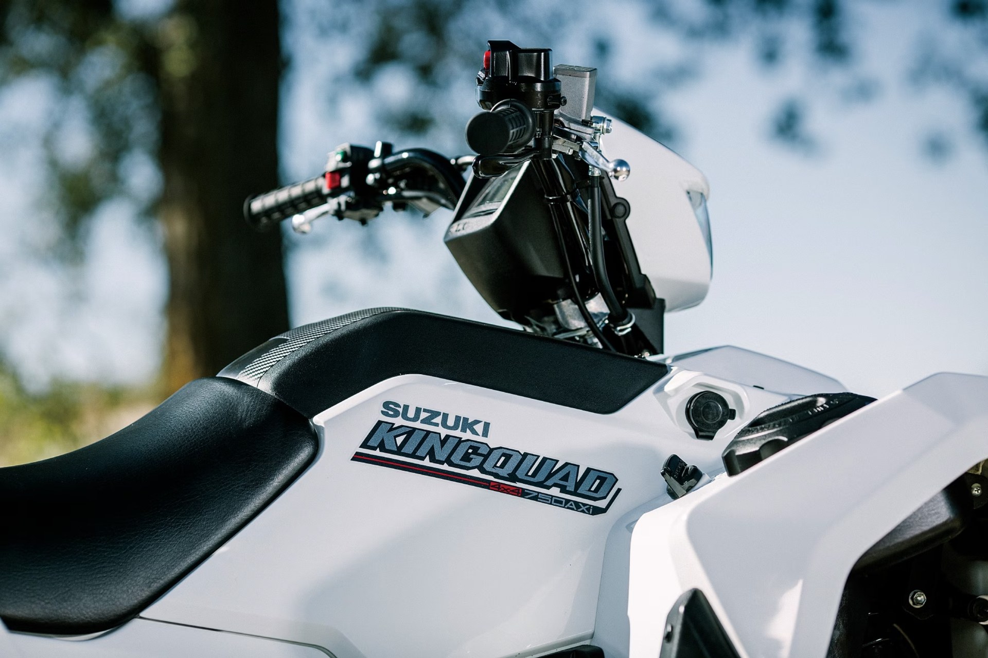 Detalle lateral del Suzuki KingQuad 750AXi blanco con asiento y manillar