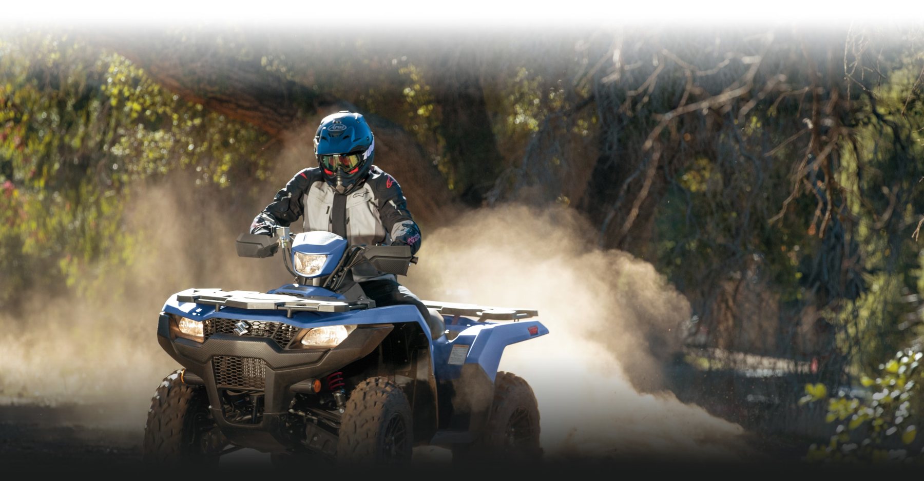 Suzuki KingQuad 750azul circulando por camino de tierra