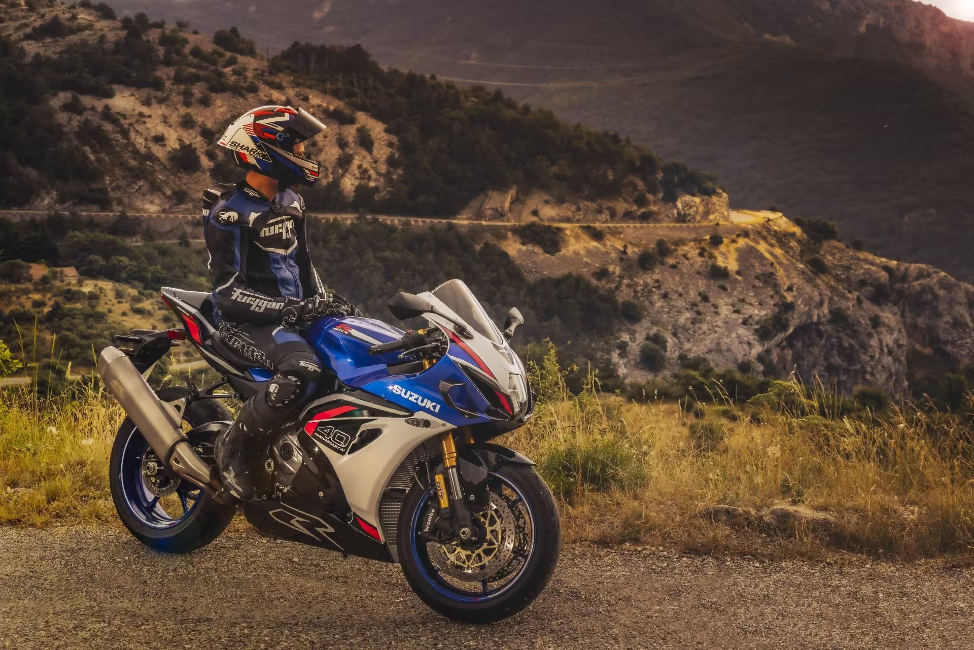 Suzuki GSX-R1000R estacionada en carretera de montaña junto a motociclista