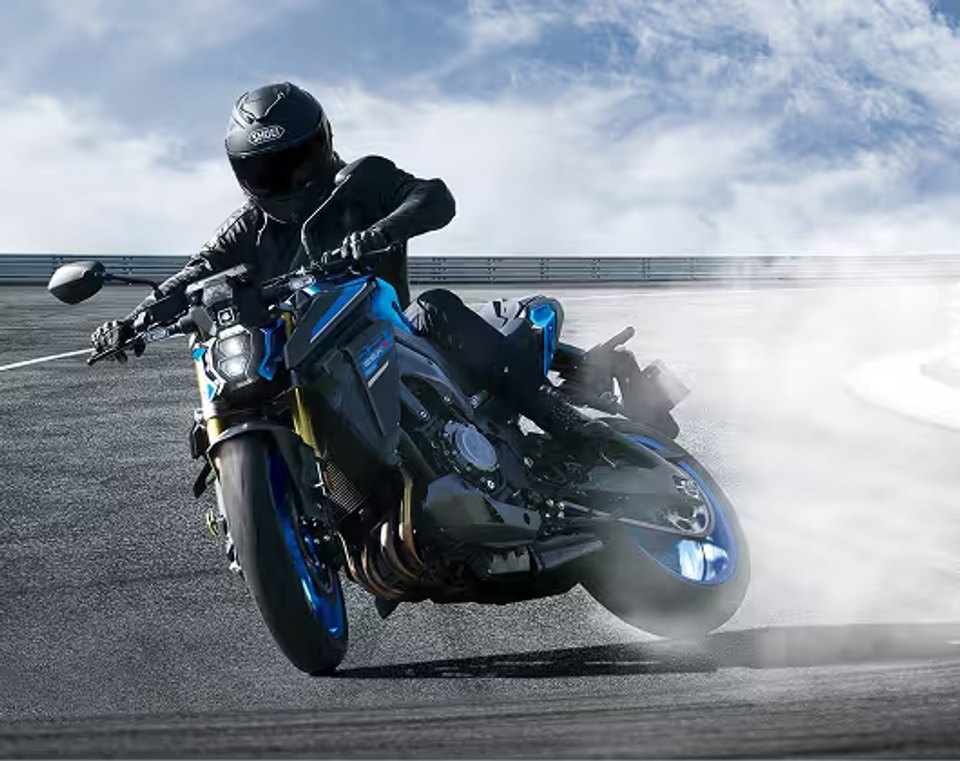 Piloto realizando una maniobra deportiva en motocicleta Suzuki GSX-S1000 azul