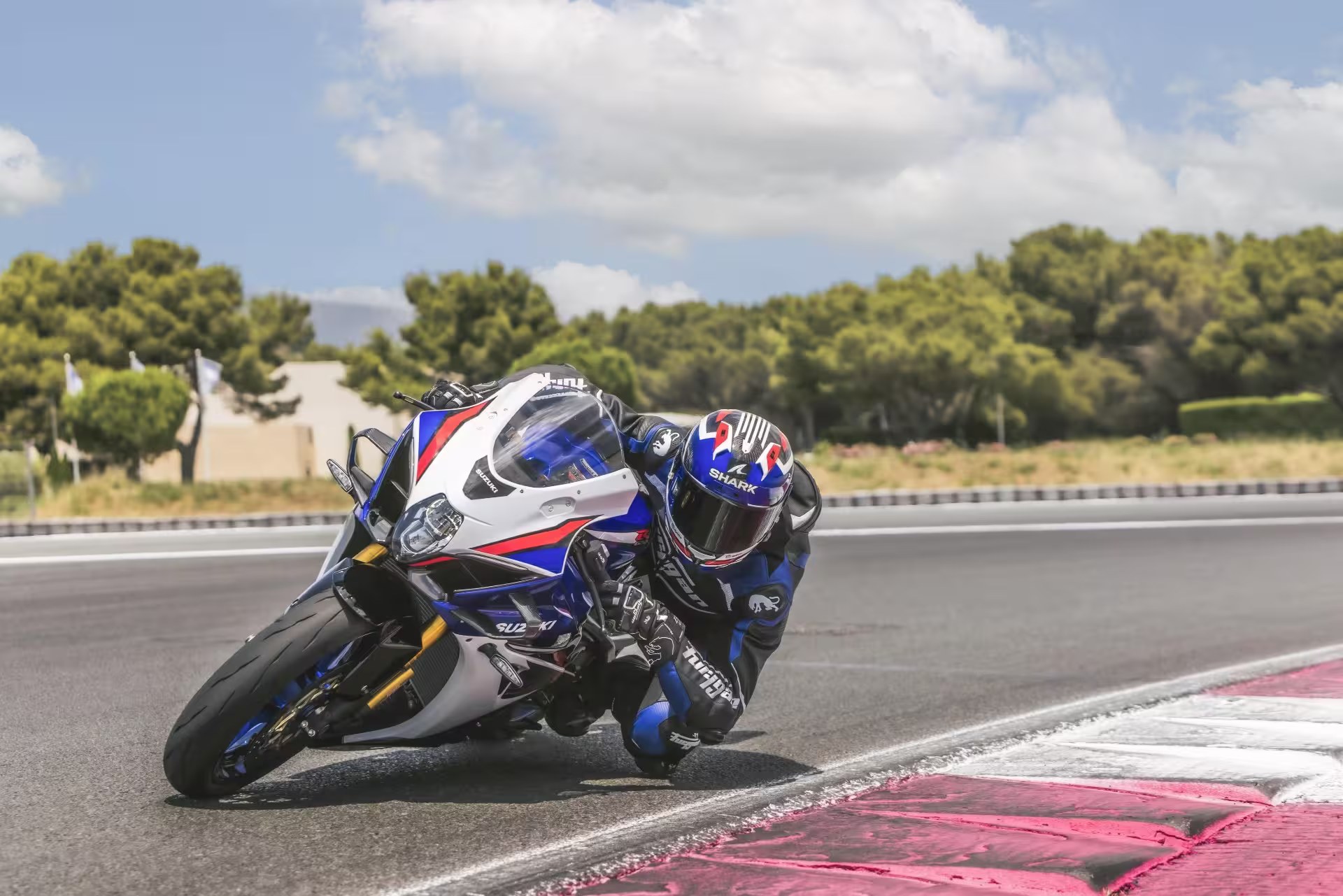 Motociclista en Suzuki GSX-R1000R tomando una curva en circuito de competición
