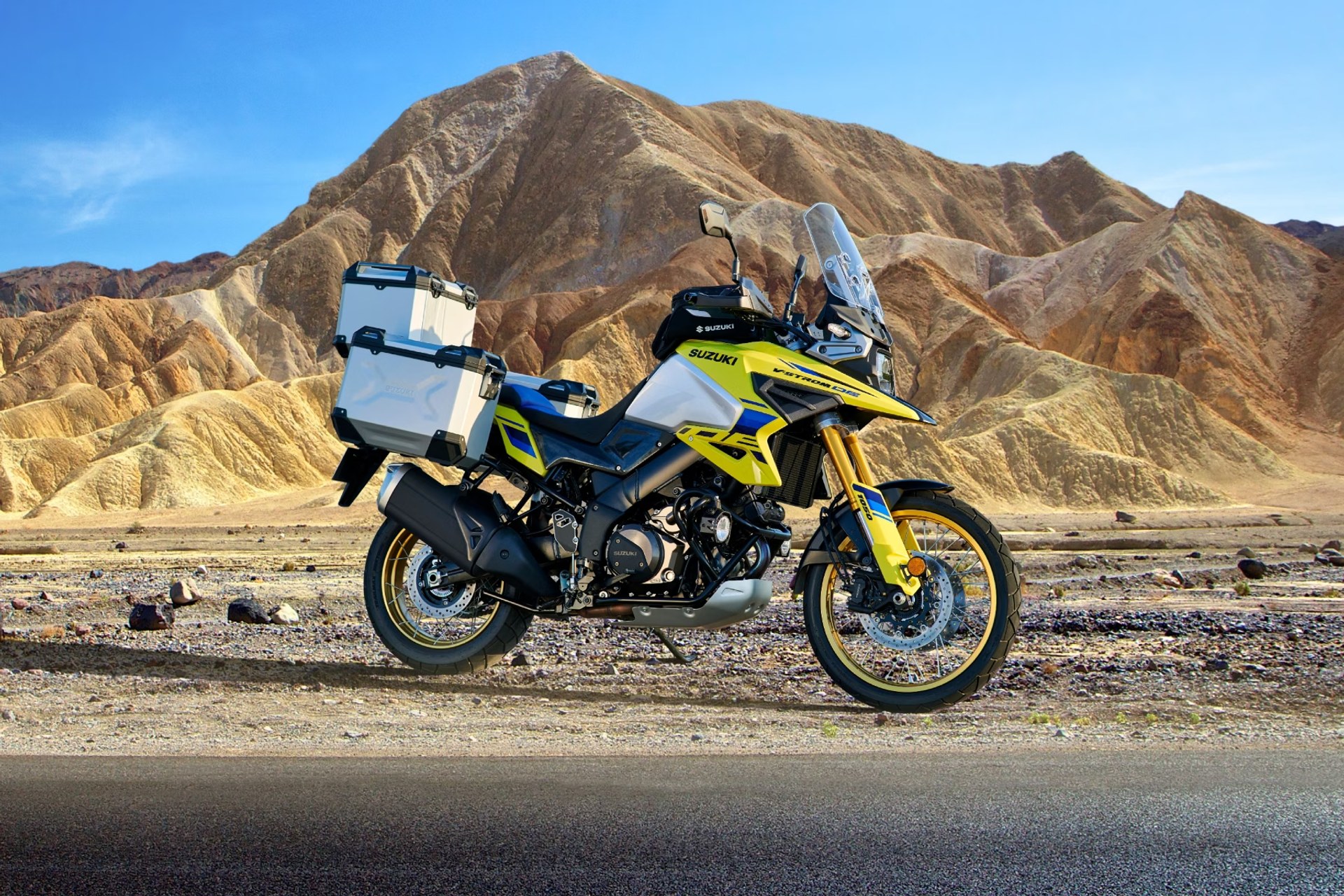 Suzuki V-Strom 1050DE amarilla con maletas en paisaje montañoso desértico