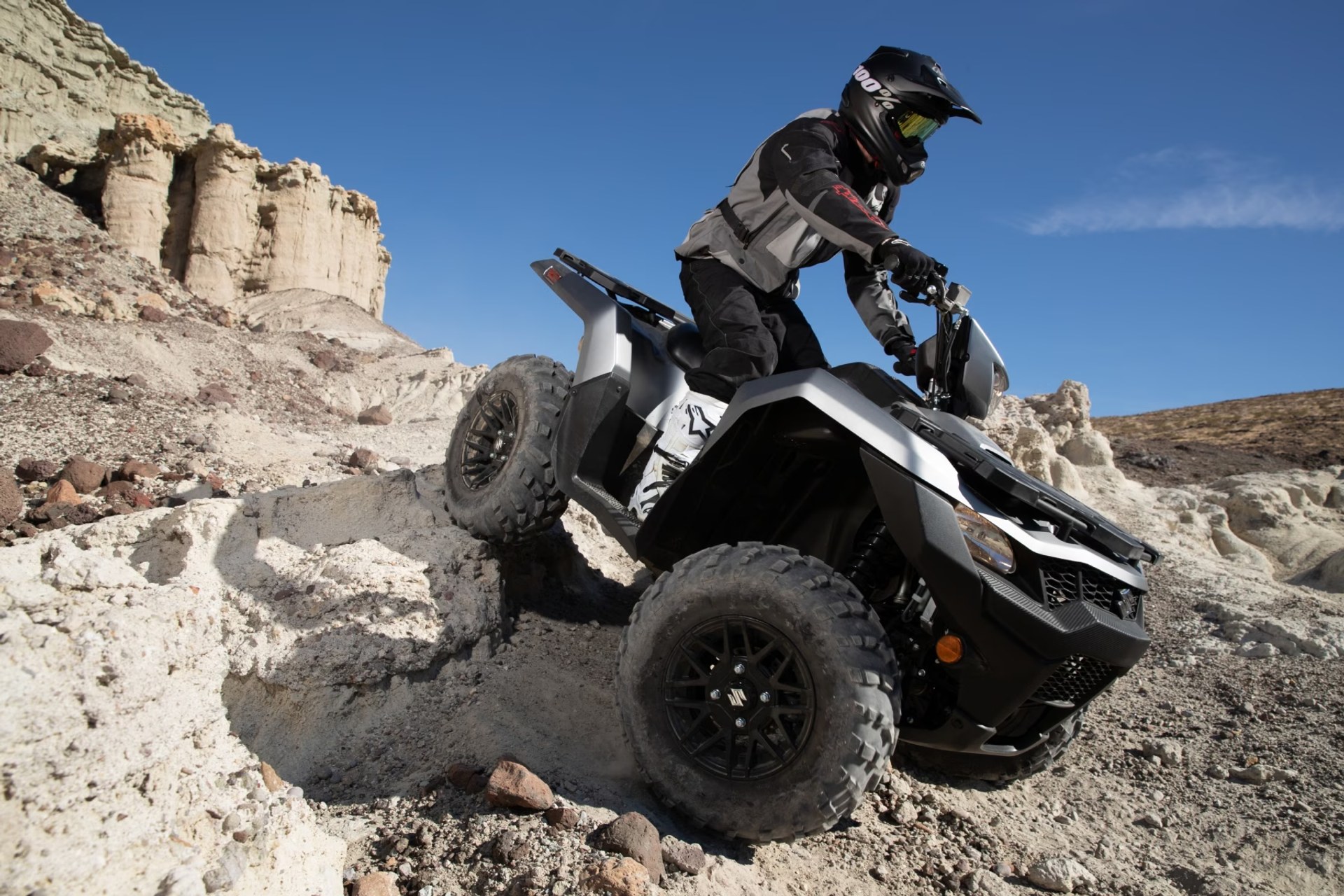 Motociclista conduciendo un Suzuki KingQuad 750 por terreno rocoso off-road