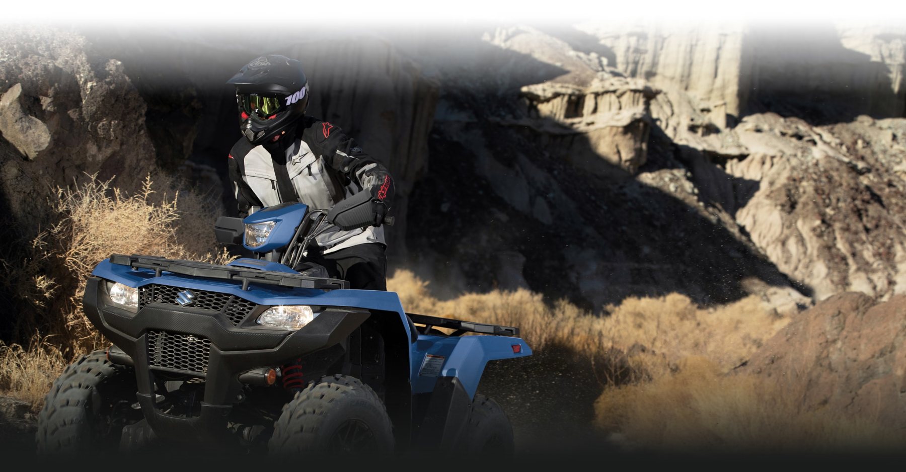 Suzuki KingQuad 500 azul conduciendo por terreno off-road