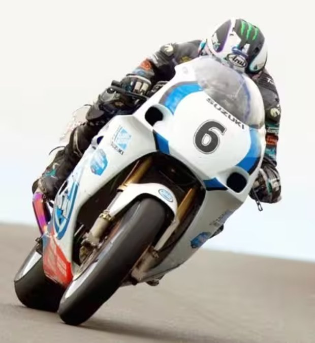 Piloto de competición conduciendo una motocicleta Suzuki de carreras número 6 en carretera
