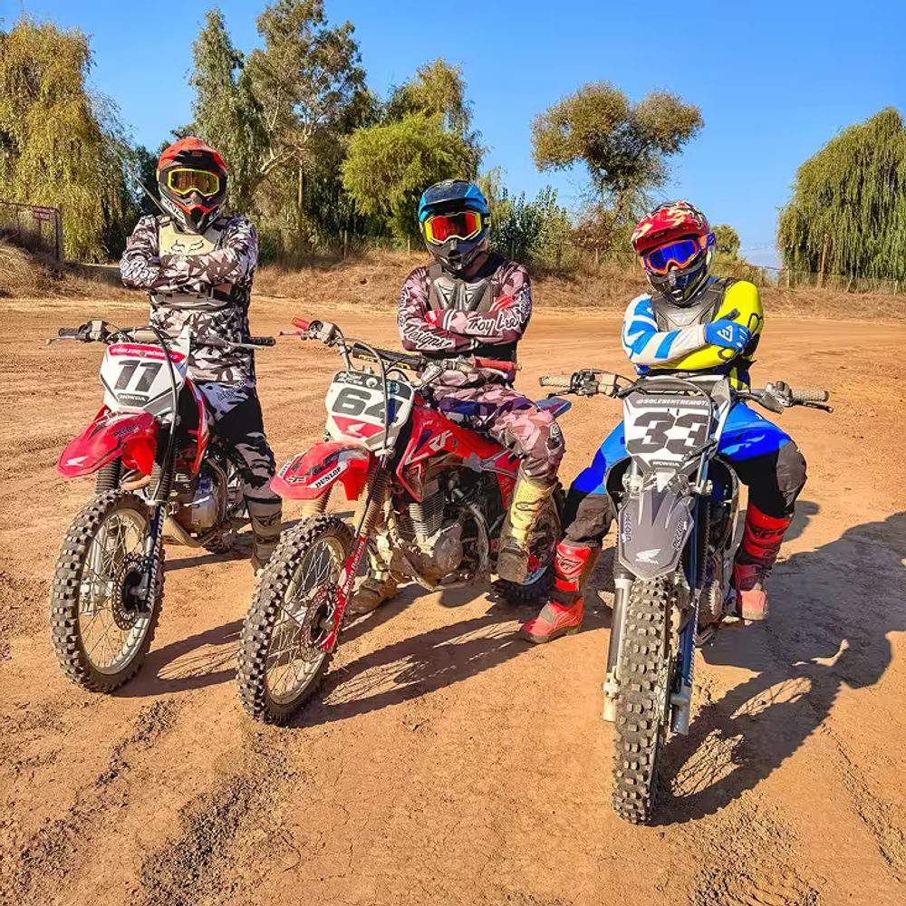 Grupo de 3 personas posando para fotografia, los 3 se encuentran en motocicleta motocross