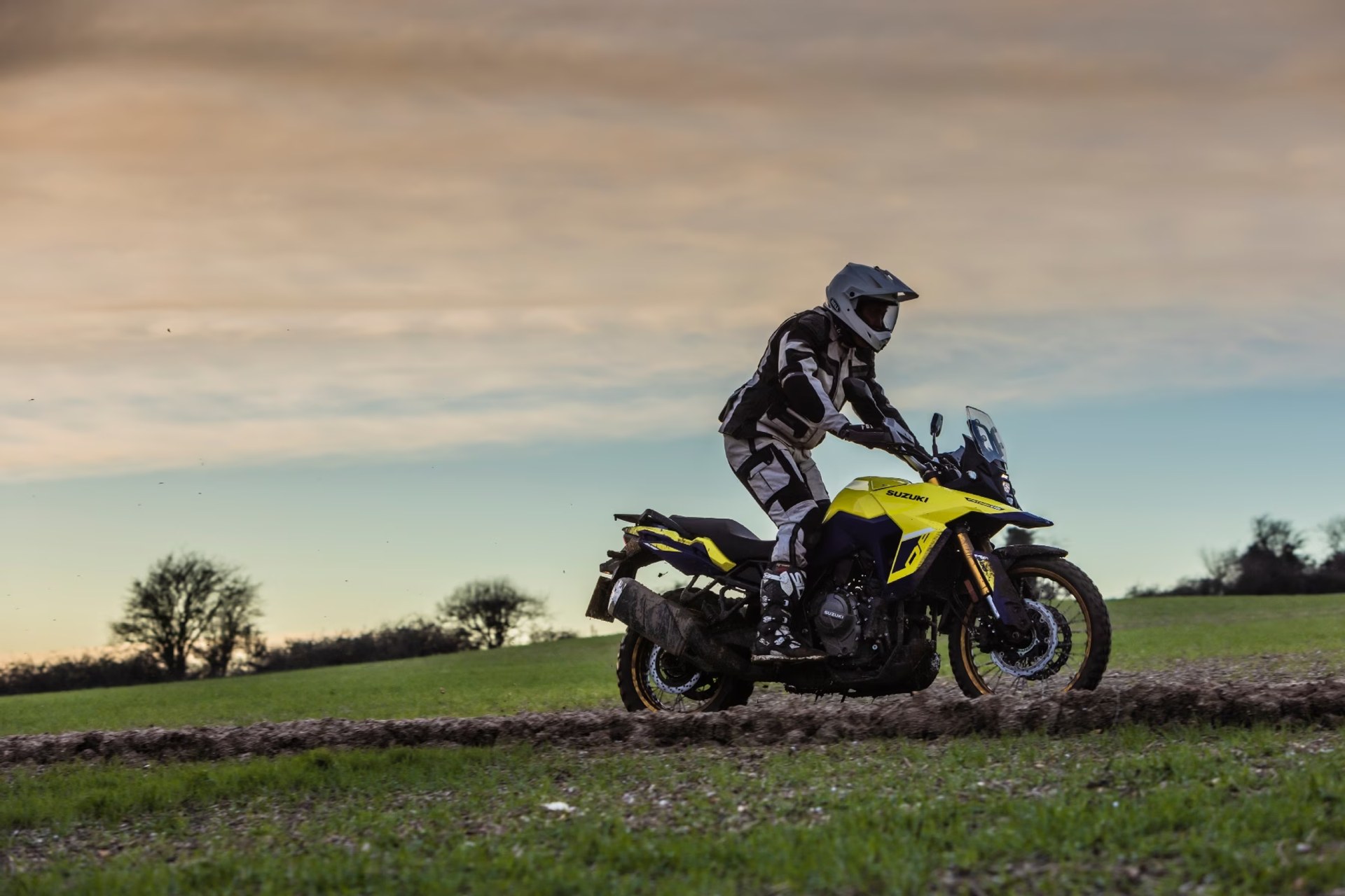 Motociclista conduciendo una Suzuki V-Strom 800DE amarilla por terreno off-road