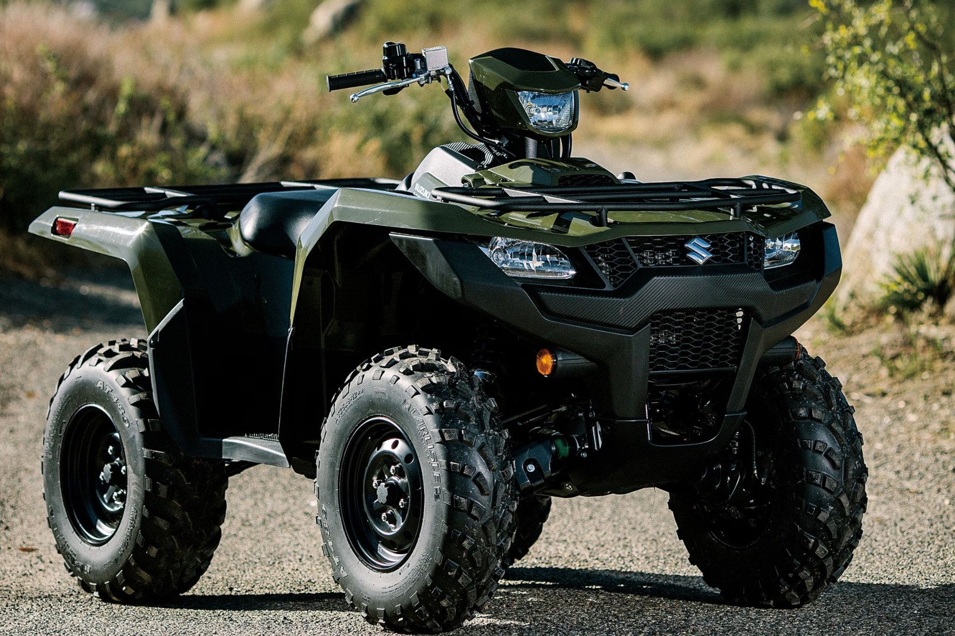 Suzuki KingQuad 750 verde en vista frontal tres cuartos sobre terreno off-road