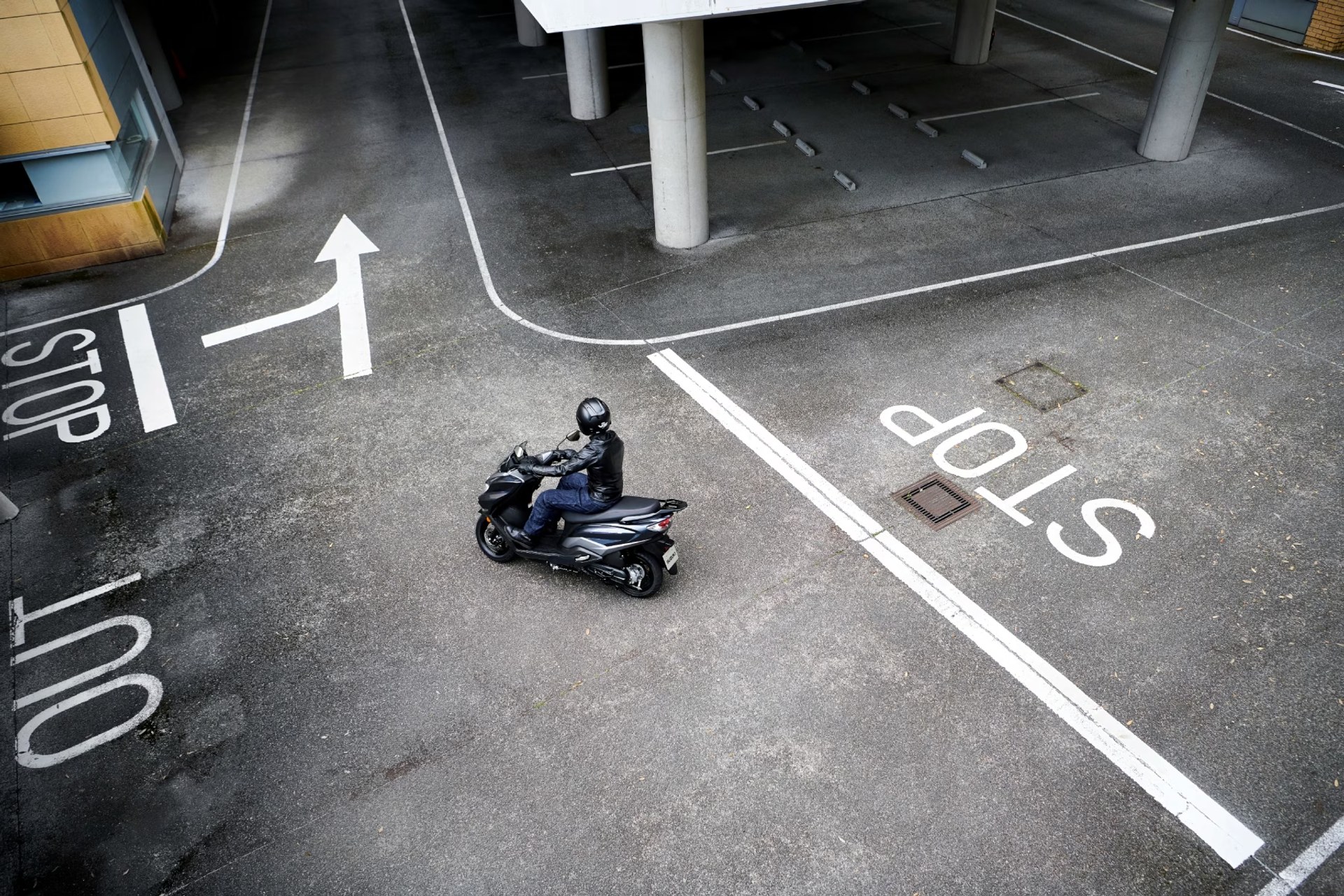 Vista aérea de un piloto en el scooter Suzuki Burgman Street 125EX circulando por un estacionamiento