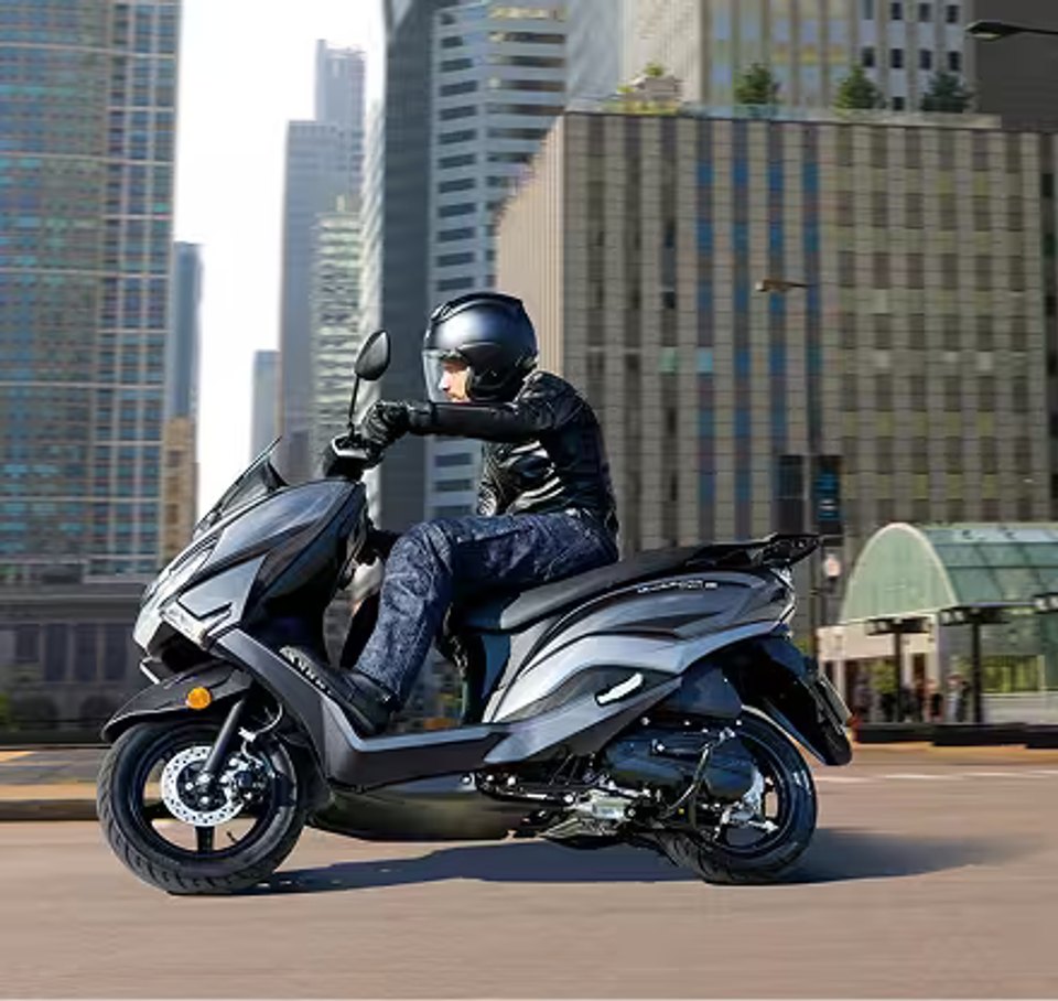 Suzuki Burgman Street 125 gris circulando por la ciudad con motociclista