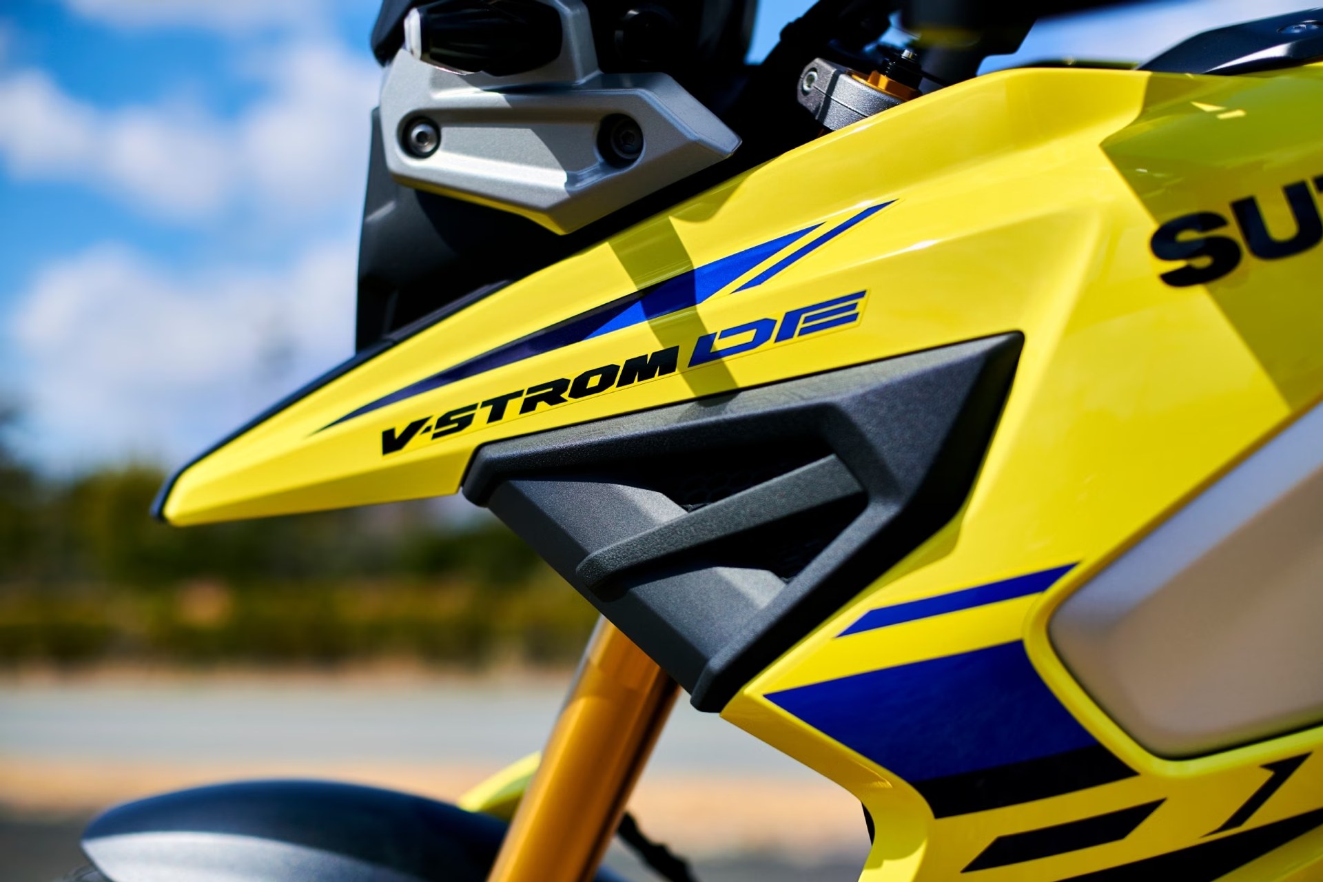 Detalle del carenado amarillo y logotipo V-Strom DE en la moto Suzuki V-Strom 1050DE