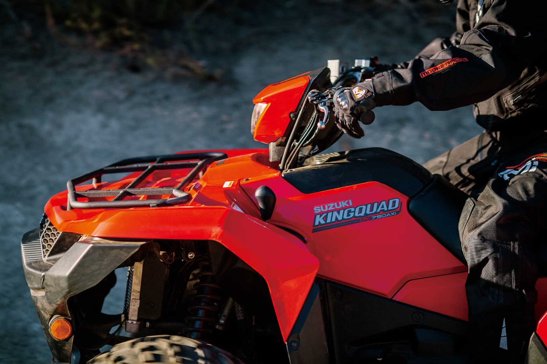 Detalle lateral del Suzuki KingQuad 750AXi rojo con conductor