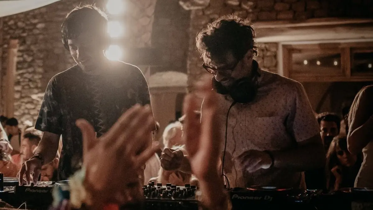 DJ performance at Scorpios Mykonos during a vibrant sunset party with guests enjoying the island's iconic nightlife.