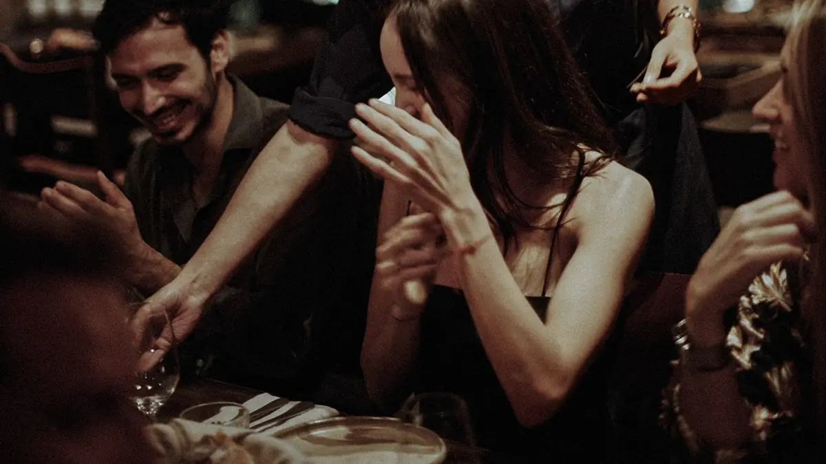 Friends enjoying a lively dinner and nightlife experience at an elegant Mykonos venue.