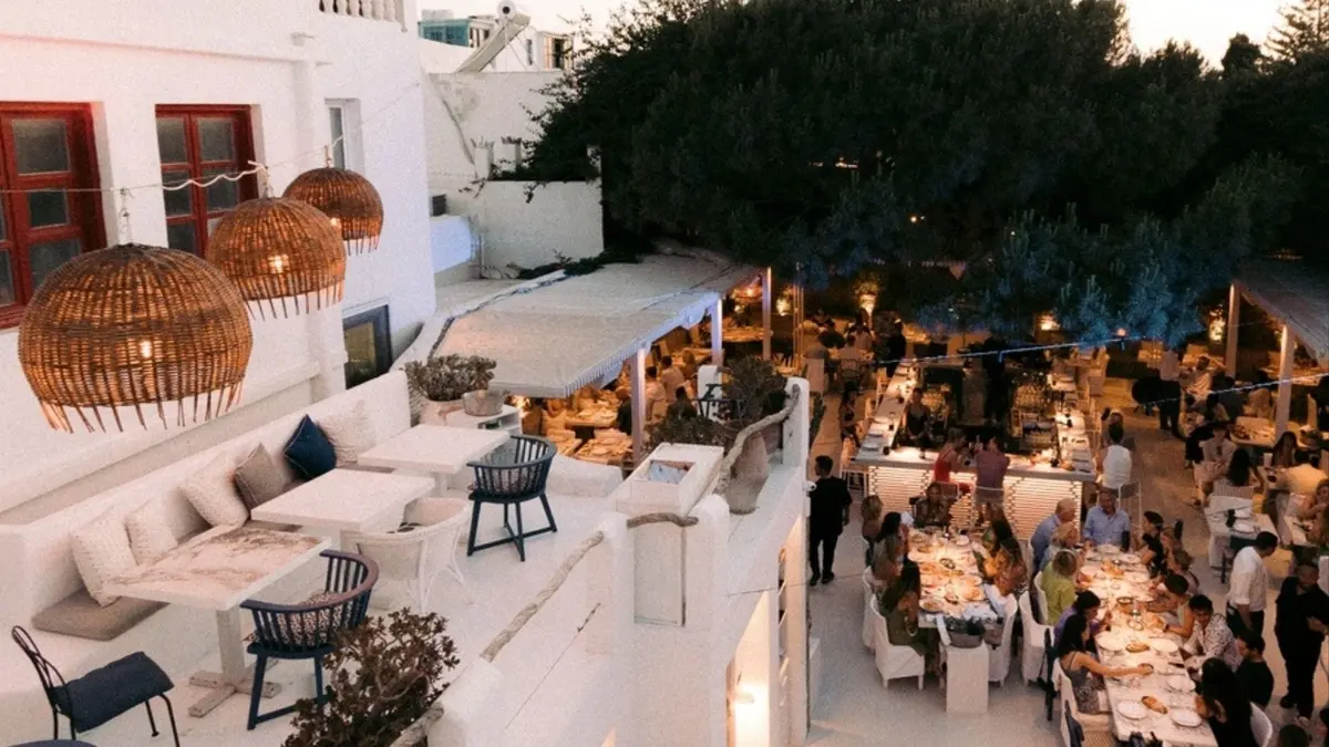 Elegant outdoor restaurant in Mykonos at sunset.