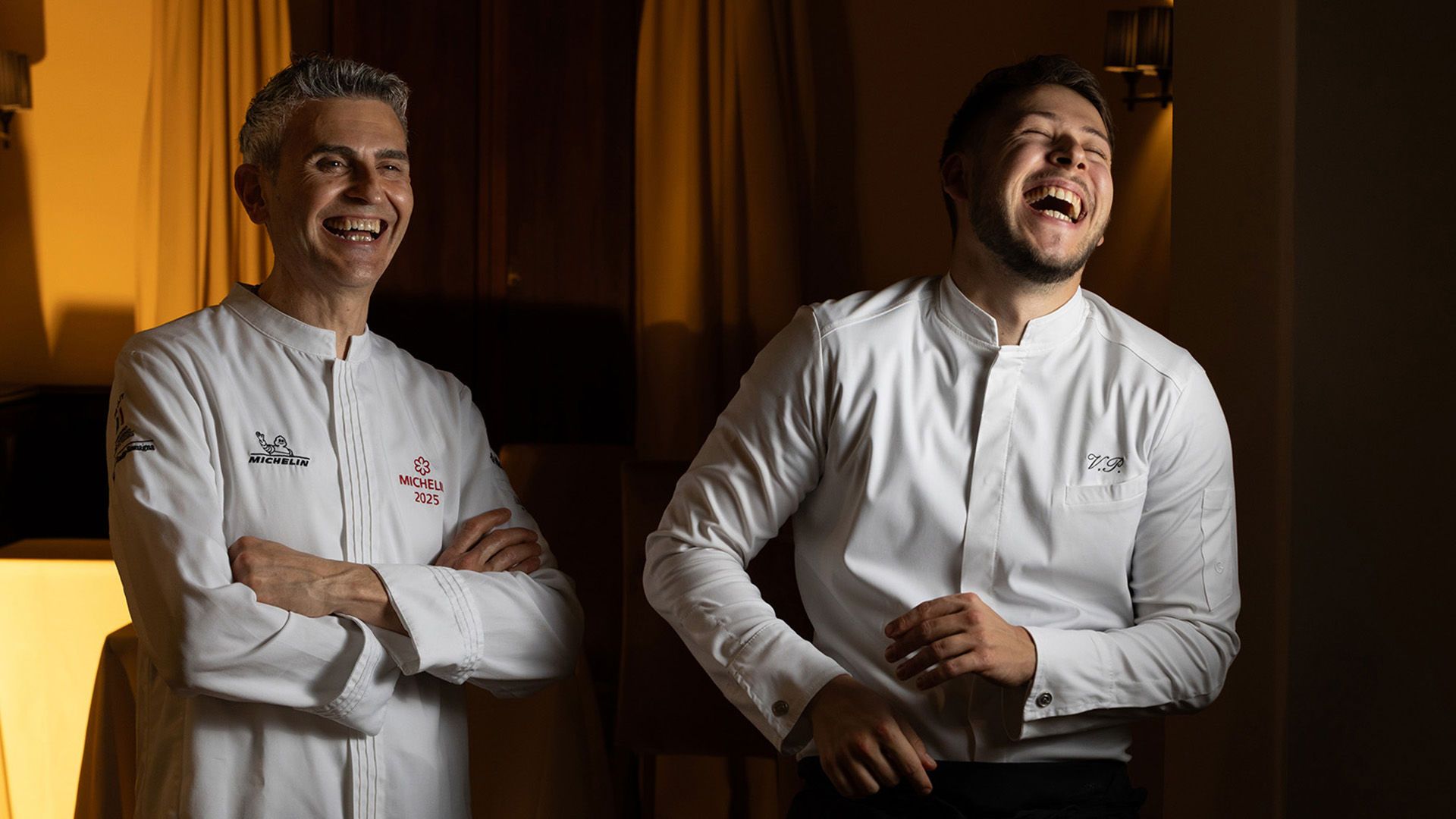 Chef Davide Canella and a member of his team at Contrada, Castel Monastero, laughing together in their whites