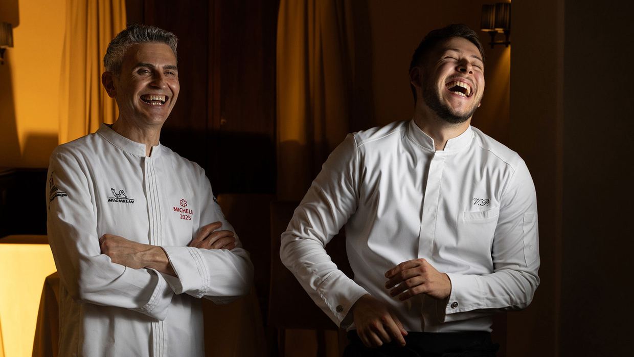 Chef Davide Canella and a member of his team at Contrada, Castel Monastero, laughing together in their whites