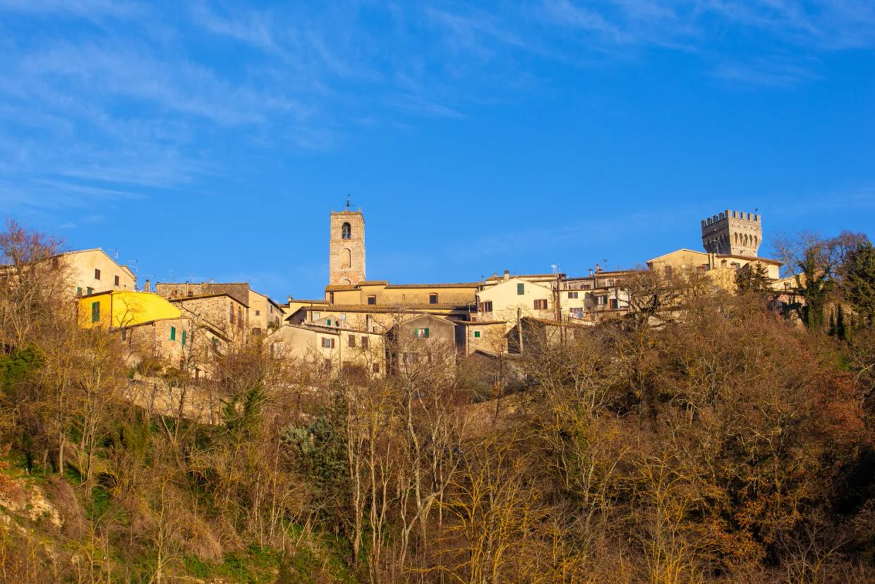 San Casciano in Val di Pesa on its hilltop, with a bell tower and a crenellated tower above the old town, in winter sun
