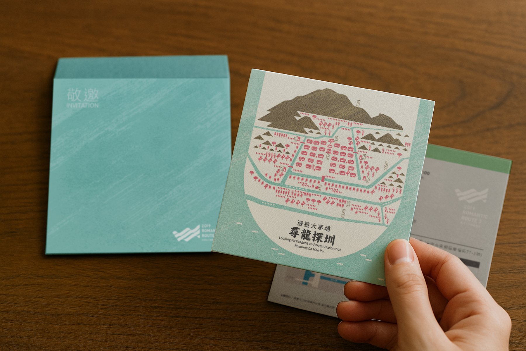 手持《尋龍探圳》活動邀請卡與素材。/  Hand holding the “Searching for the Dragon in the Irrigation System” invitation card and print materials.
