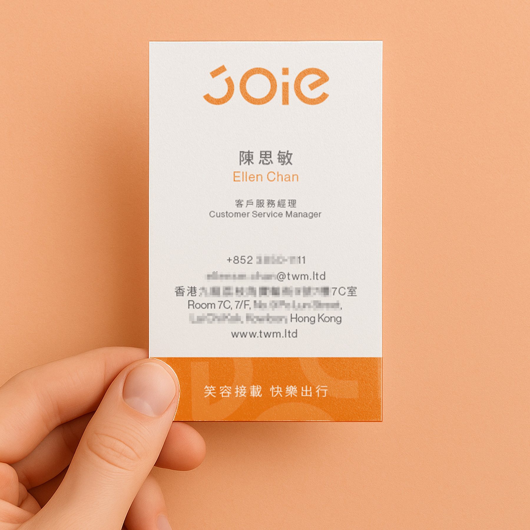 手持 JOIE 樂行計程車橘色名片（正面設計展示） / Hand holding JOIE Taxi orange business card – front design.
