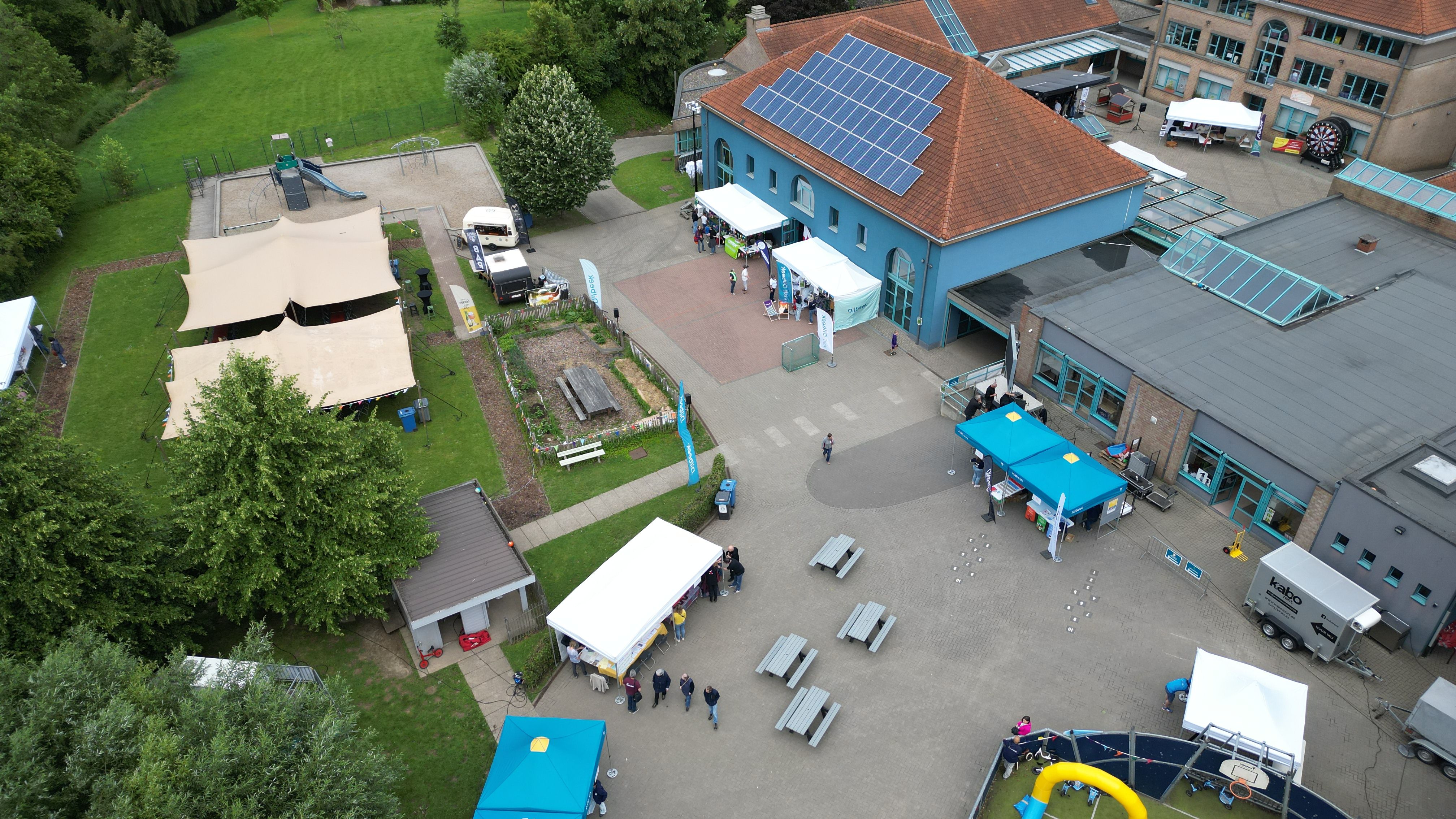 Overzicht van het evenemententerrein tijdens de Dag van de Dilbekenaar 2026 in Groot-Bijgaarden, met standhouders, tenten en publiek verspreid over de buitenlocatie