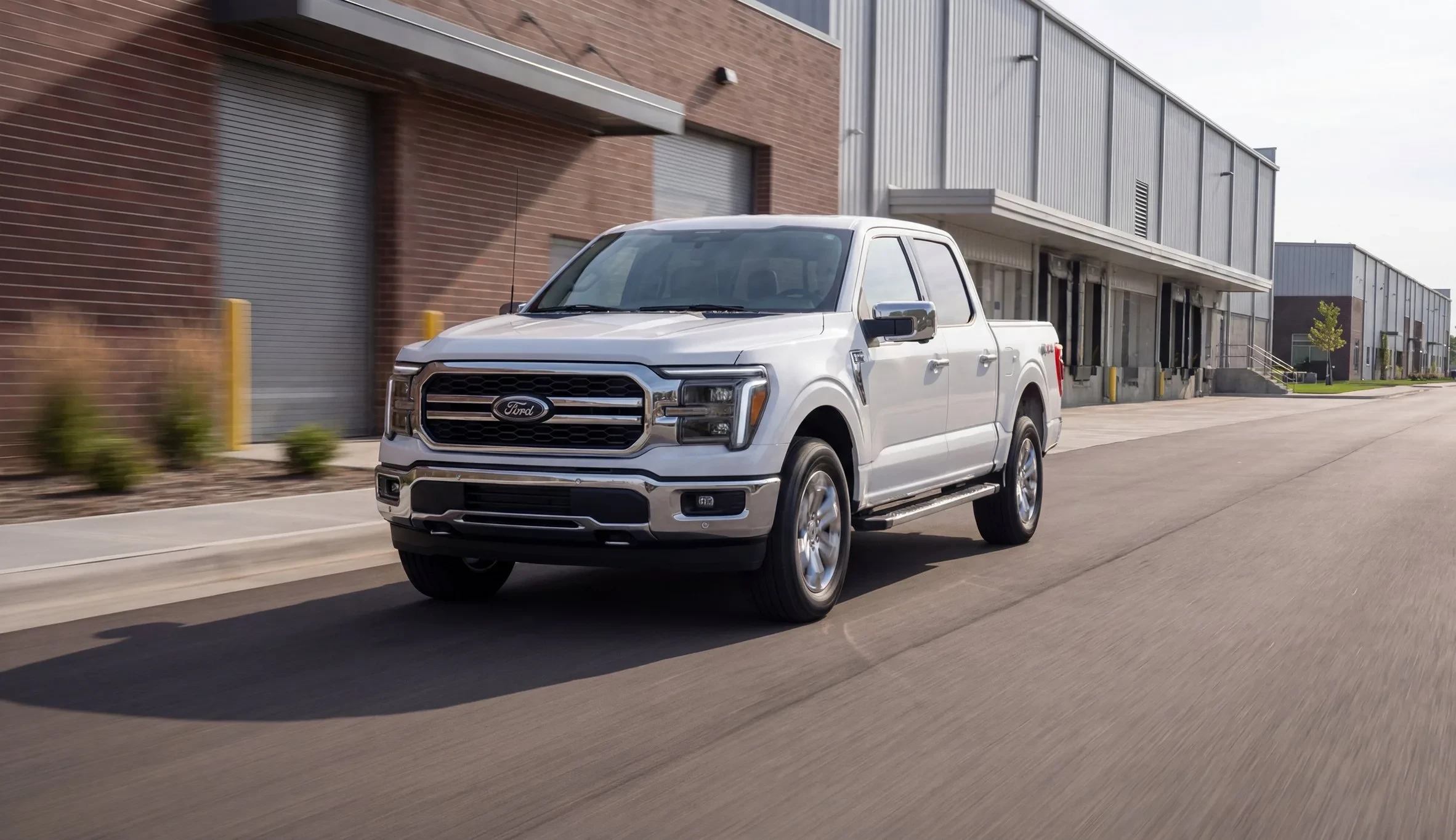 White pickup truck driving past a warehouse