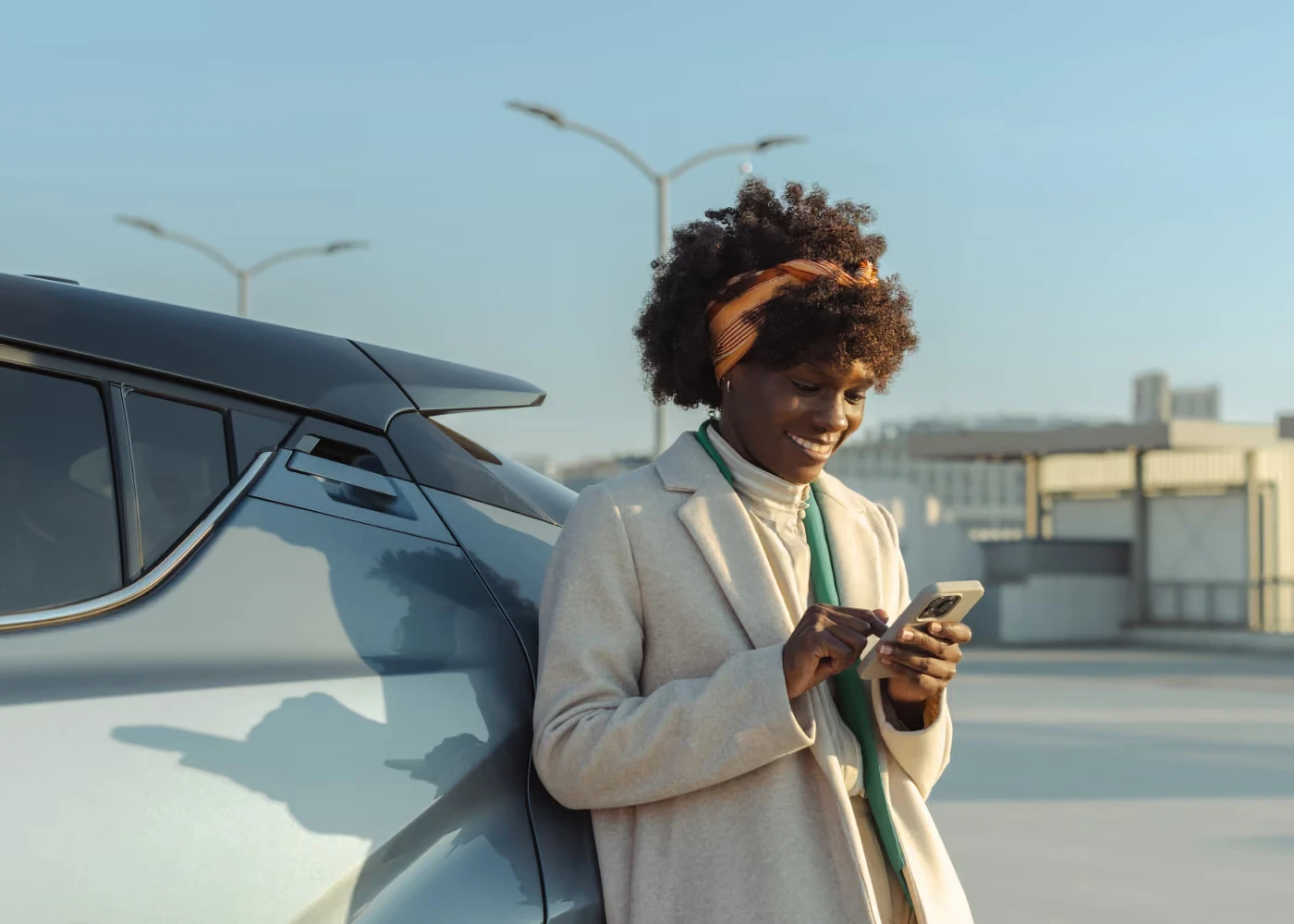 Woman beside a car using the Self Inspection app on her phone