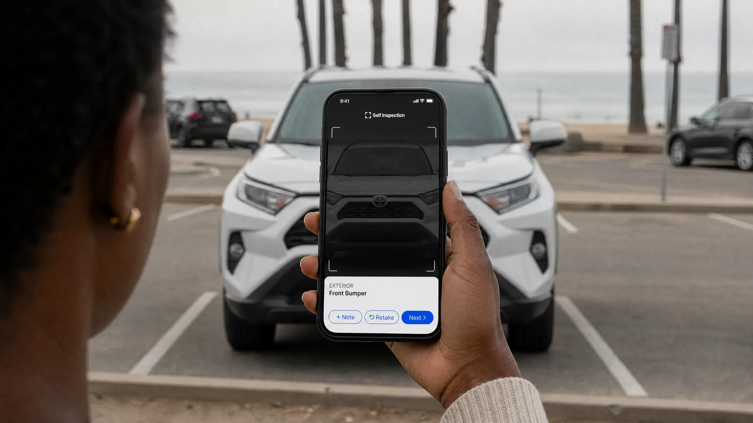 Person holding a phone running Self Inspection guided capture on the front bumper of a white SUV