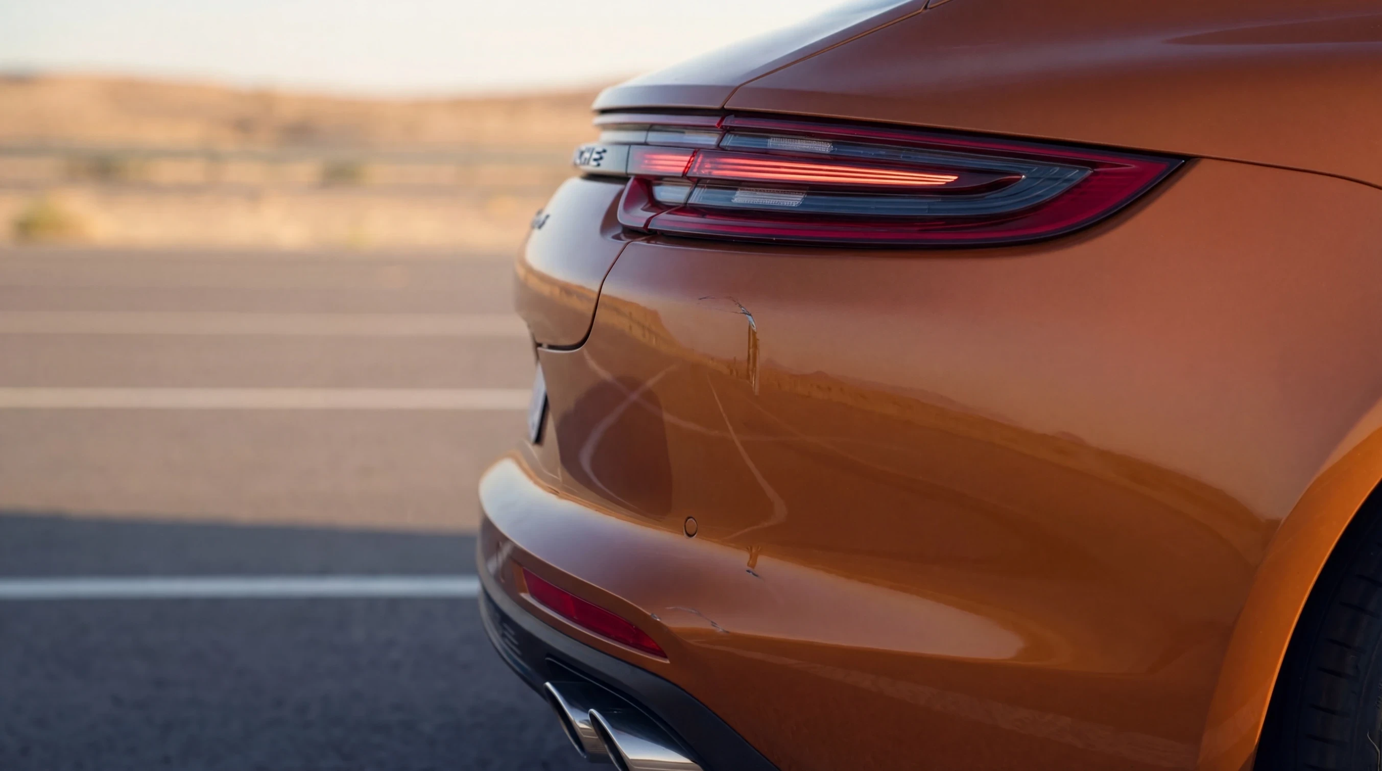 Scratches on the rear bumper of an orange sedan