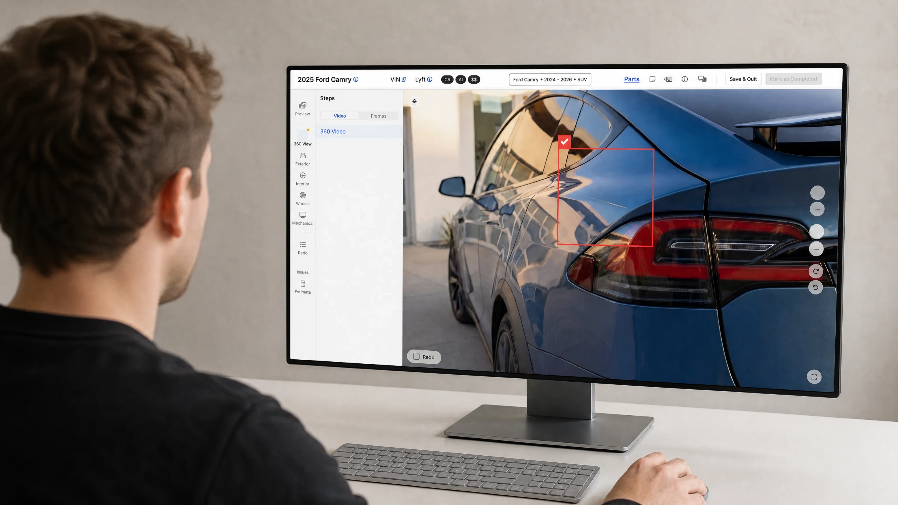 Reviewer at a desktop confirming an AI-detected dent above the tail lamp of a blue SUV in the inspection review screen