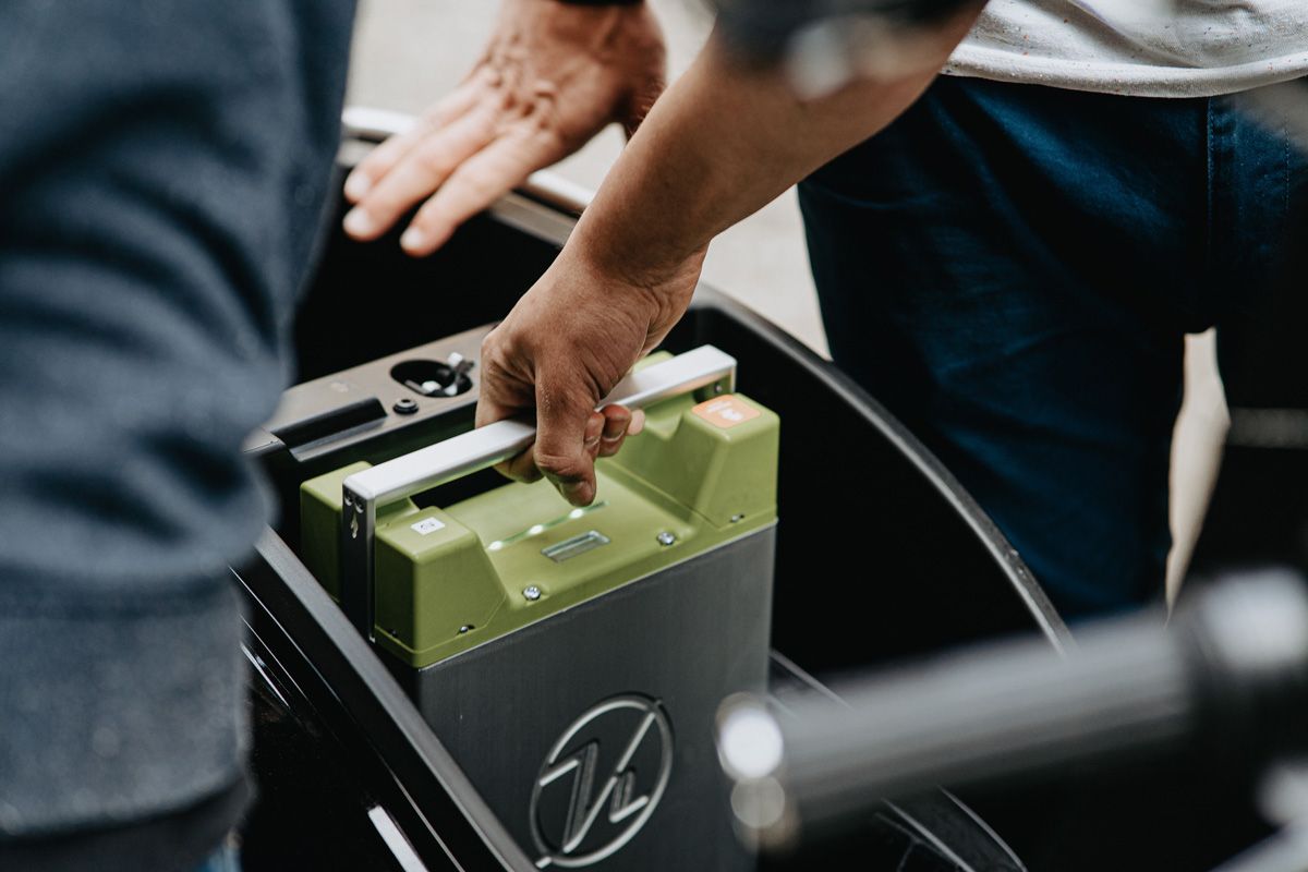 Man pulling up a battery in electrical car