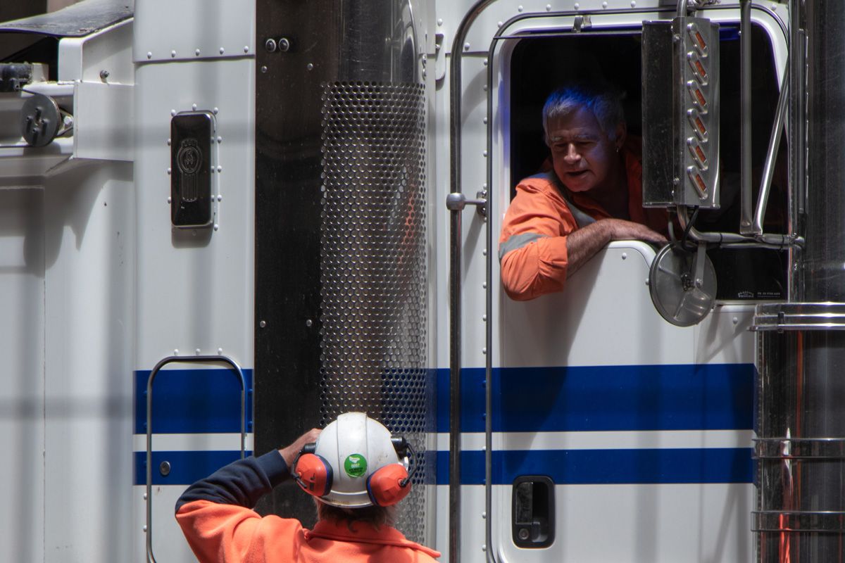 One industrial worker talking to another worker in a truck