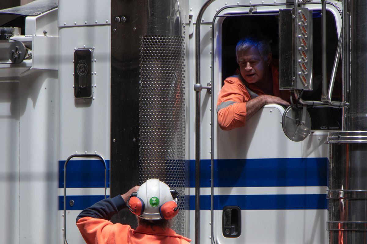 One industrial worker talking to another worker in a truck