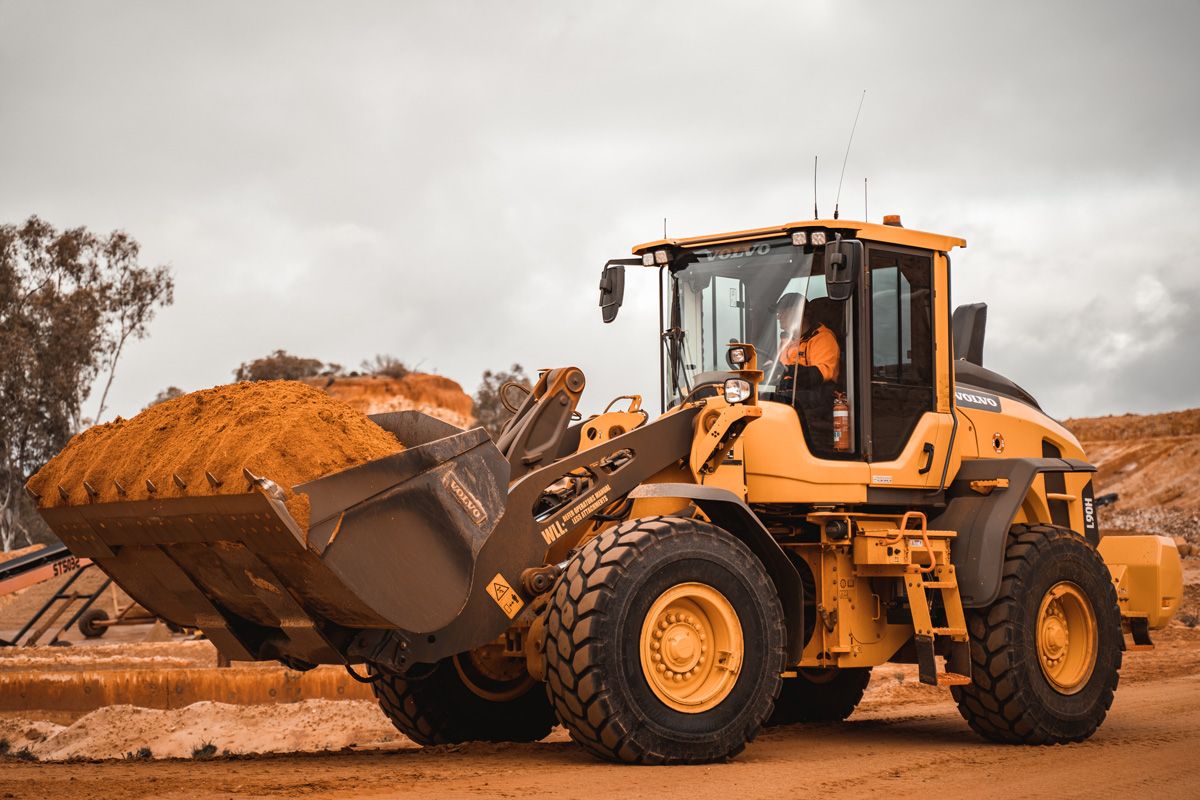 Tractor in a mine carrying red dirt