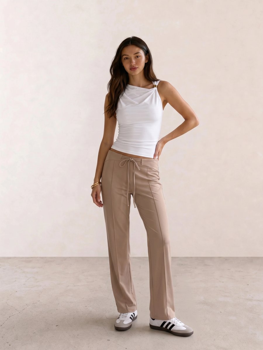 Basic casual outfit with a white draped tank, beige drawstring trousers, and white Adidas Samba sneakers