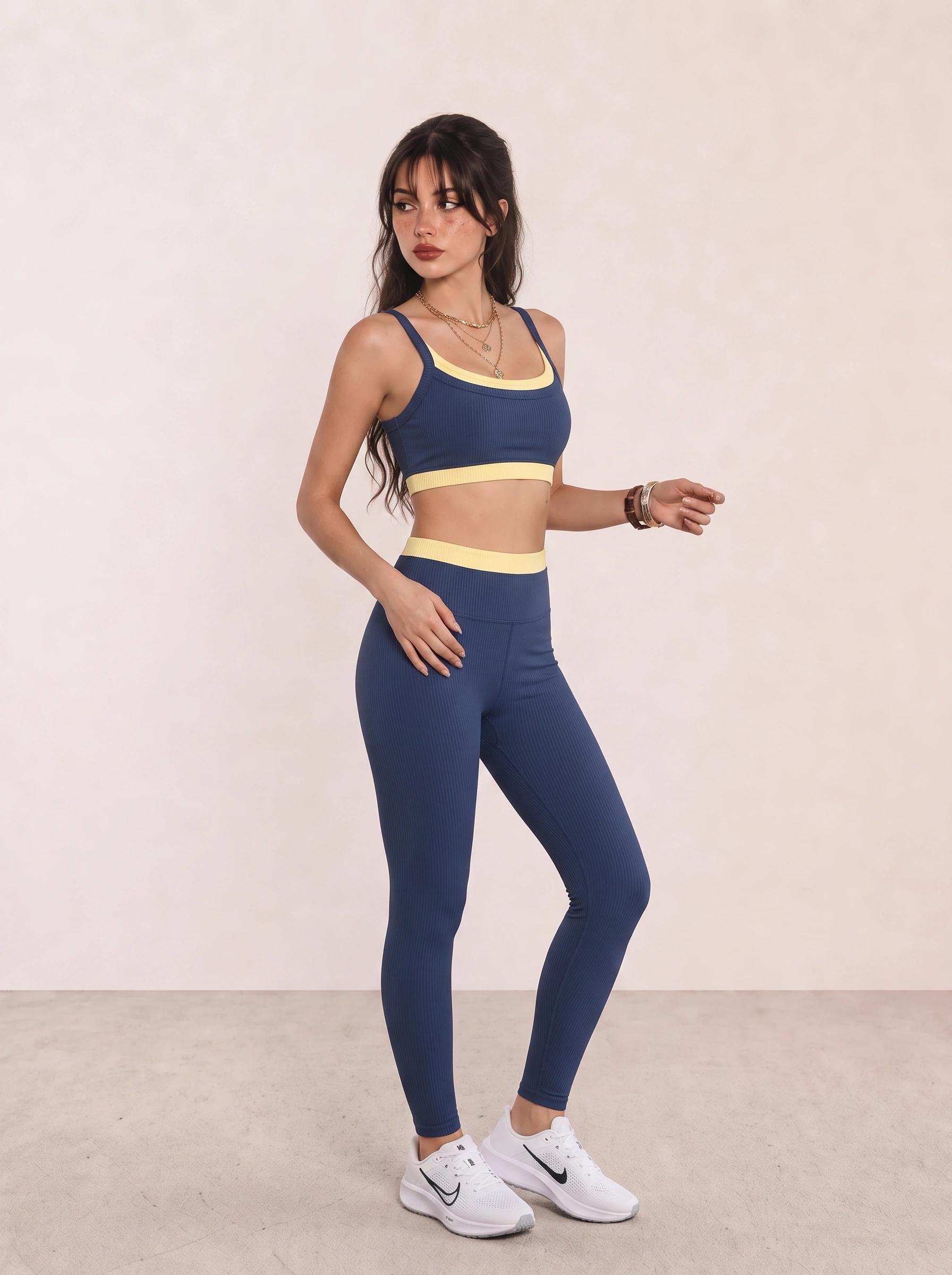 Woman wearing a navy sports bra, navy leggings, and white running shoes