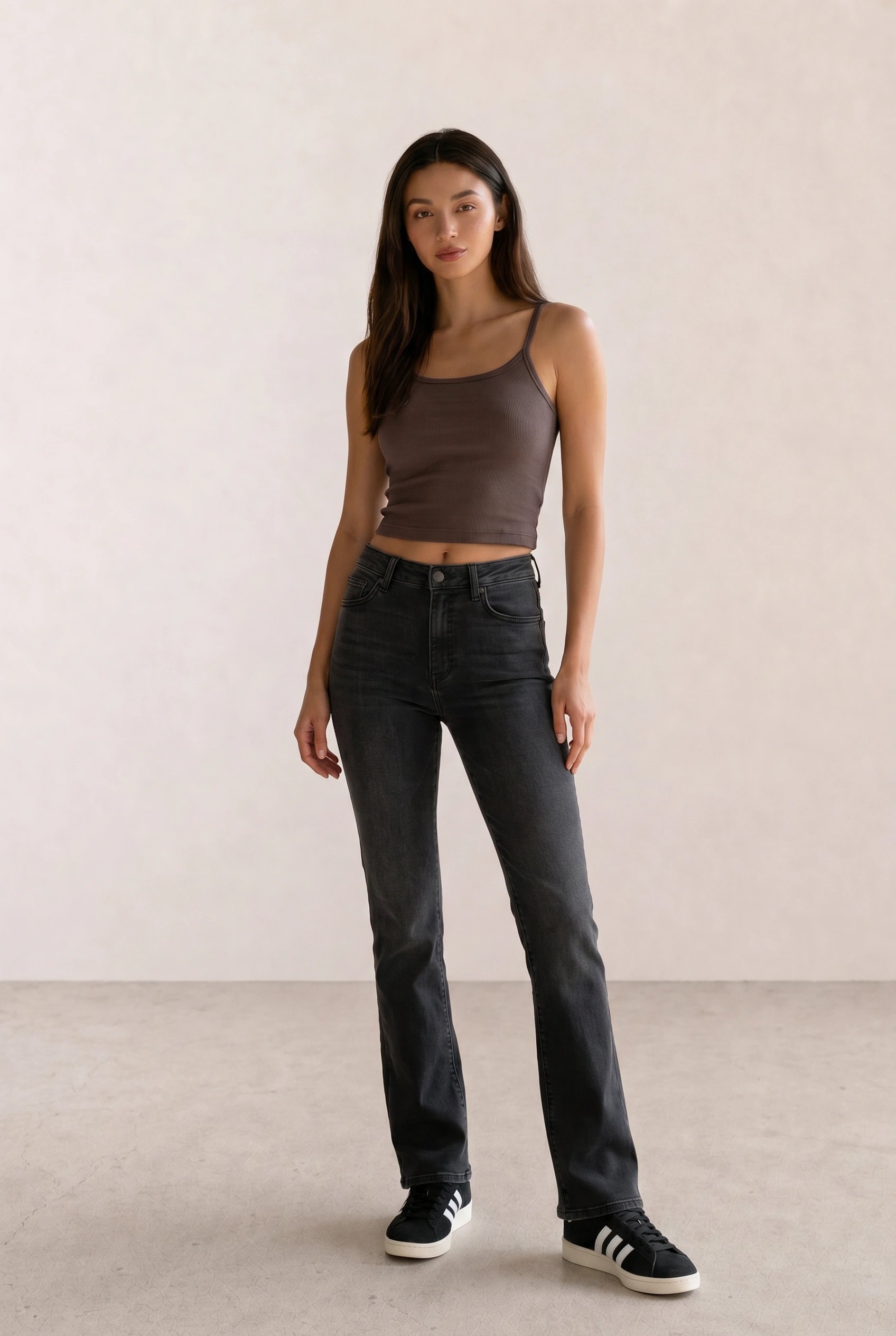 Basic casual outfit with a taupe ribbed tank, black bootcut jeans, and black Adidas Campus sneakers