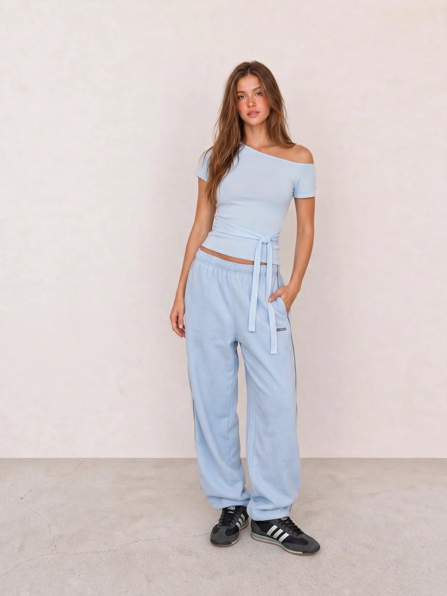 Korean fashion outfit with a light blue wrap top, light blue jogger pants, and black Adidas sneakers