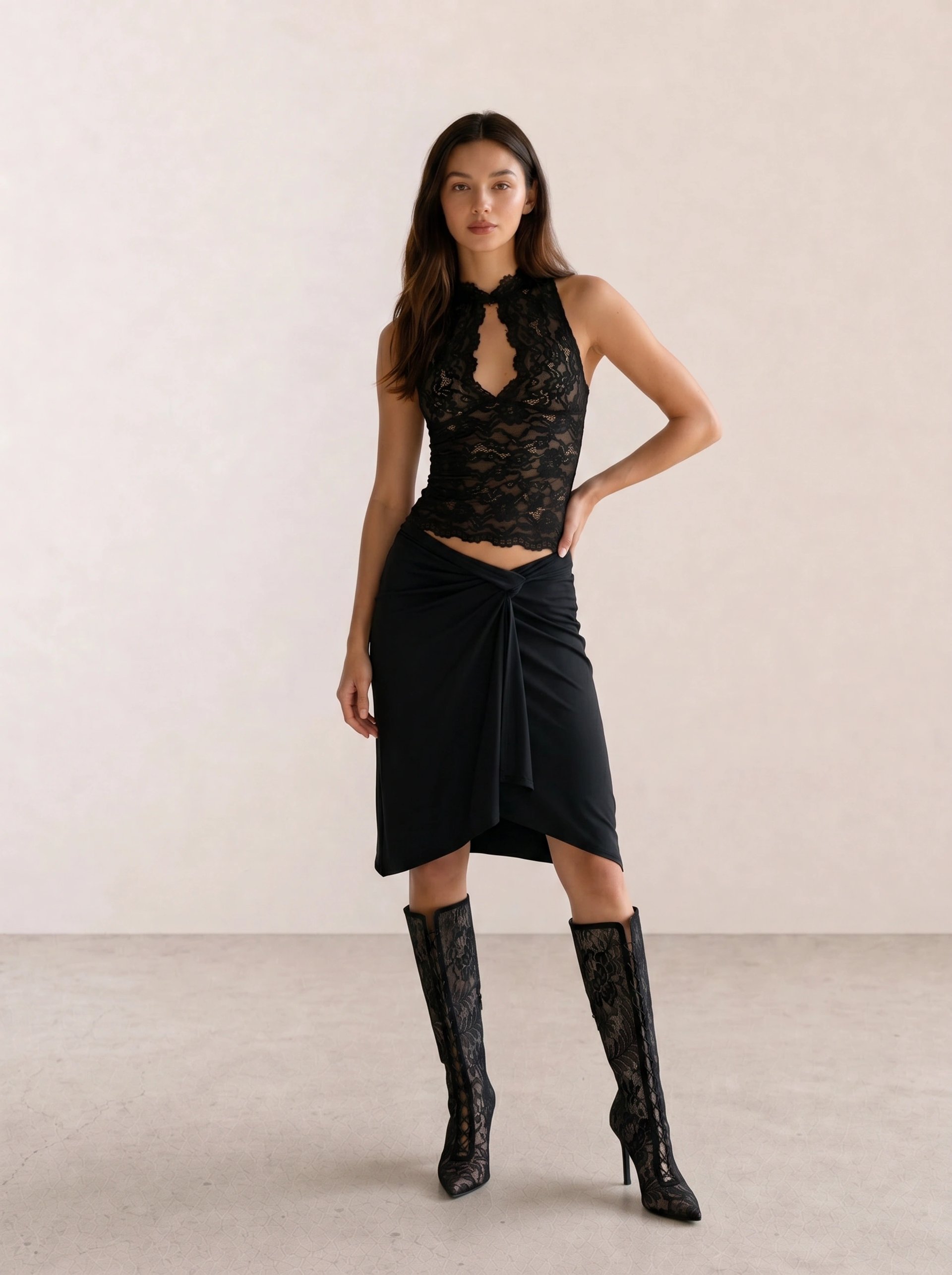 Black outfit with a sheer lace halter top, twist-front midi skirt, and lace knee-high boots