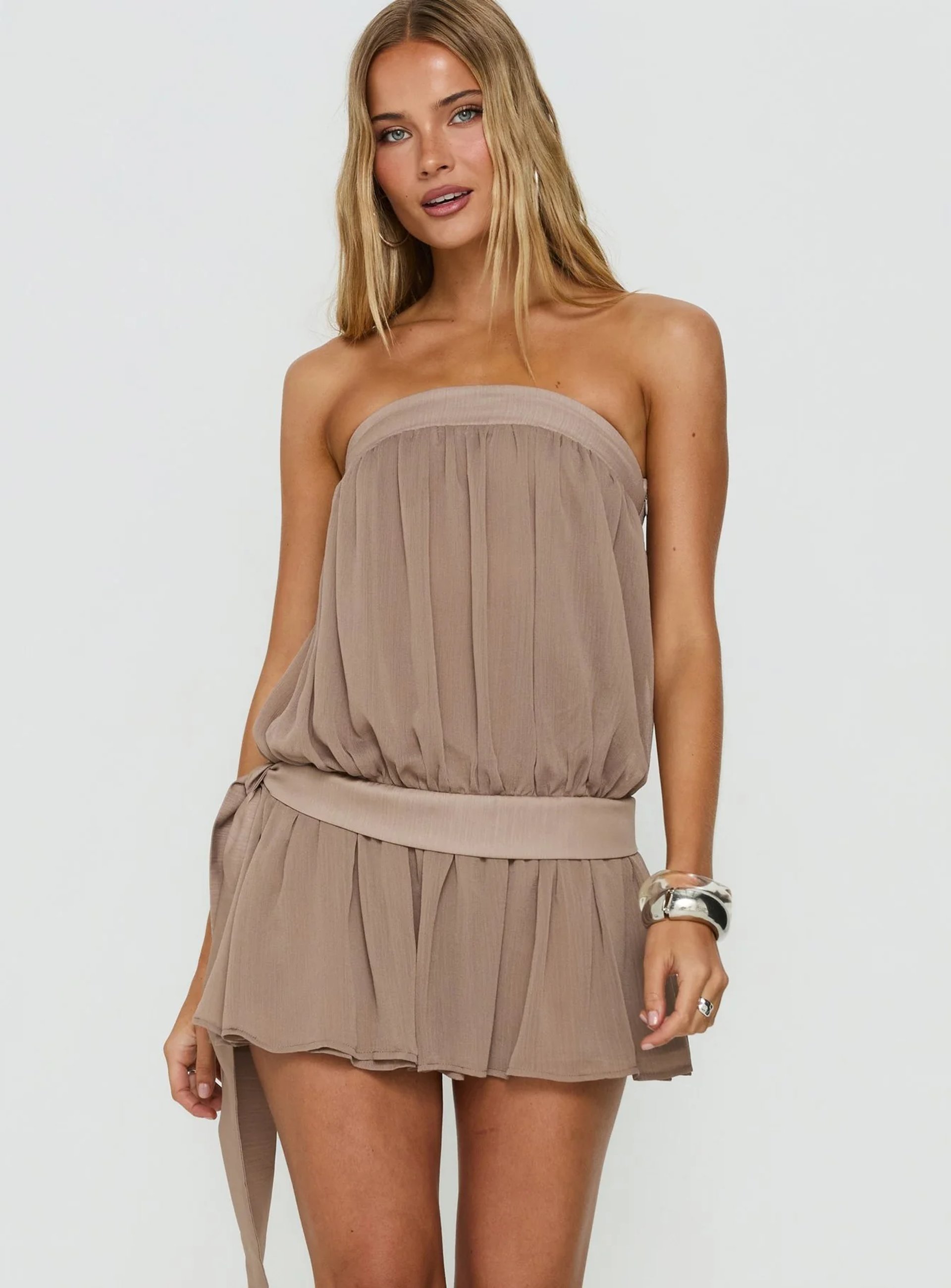 Taupe strapless ruffle mini dress styled with brown embroidered western boots and a black belt bag