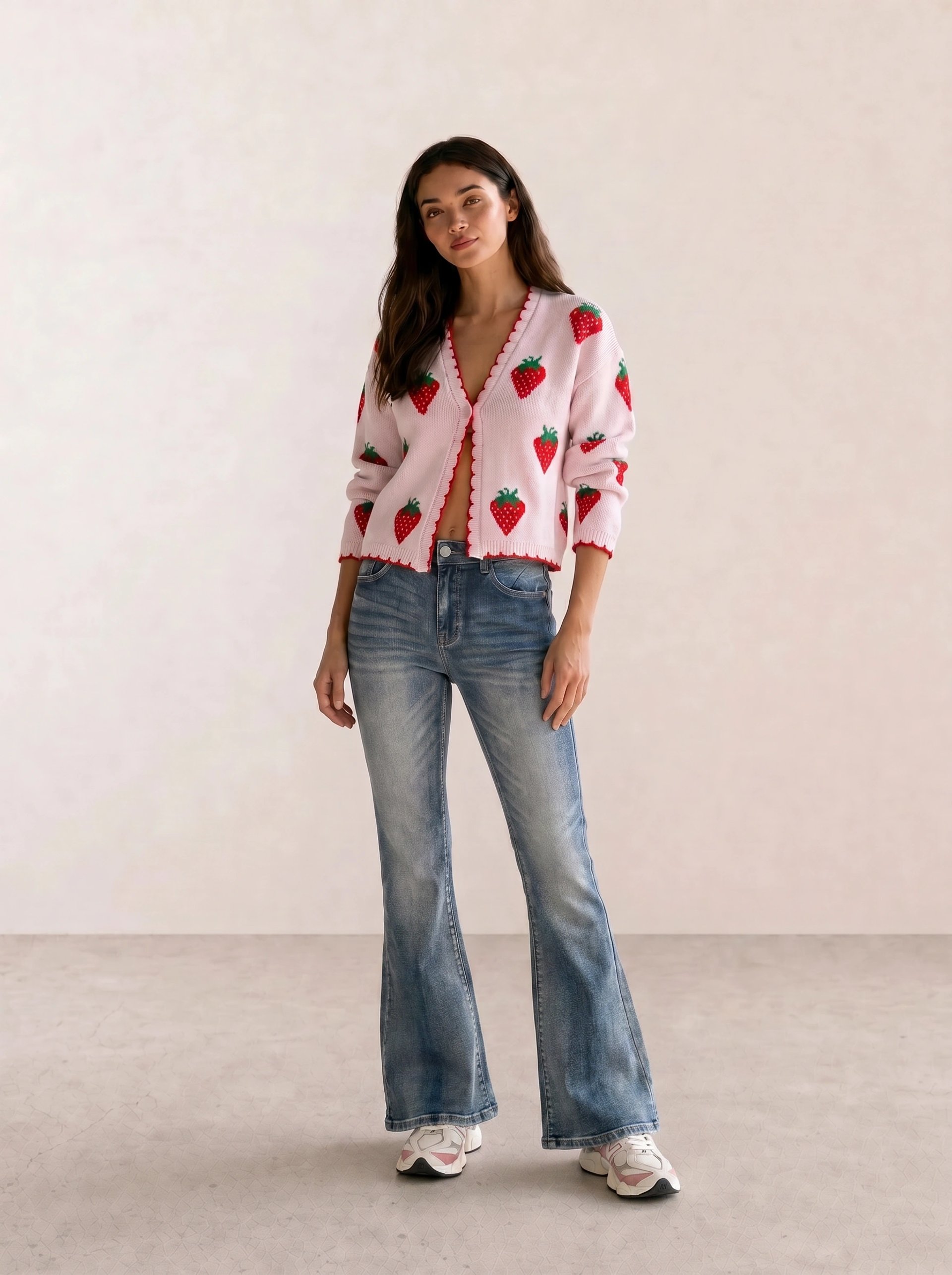 Pink strawberry print knit cardigan with light wash flared jeans and white chunky platform sneakers