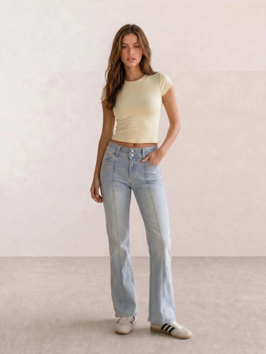 Basic casual outfit with a pale yellow ribbed tee, light wash flare jeans, and cream Adidas sneakers