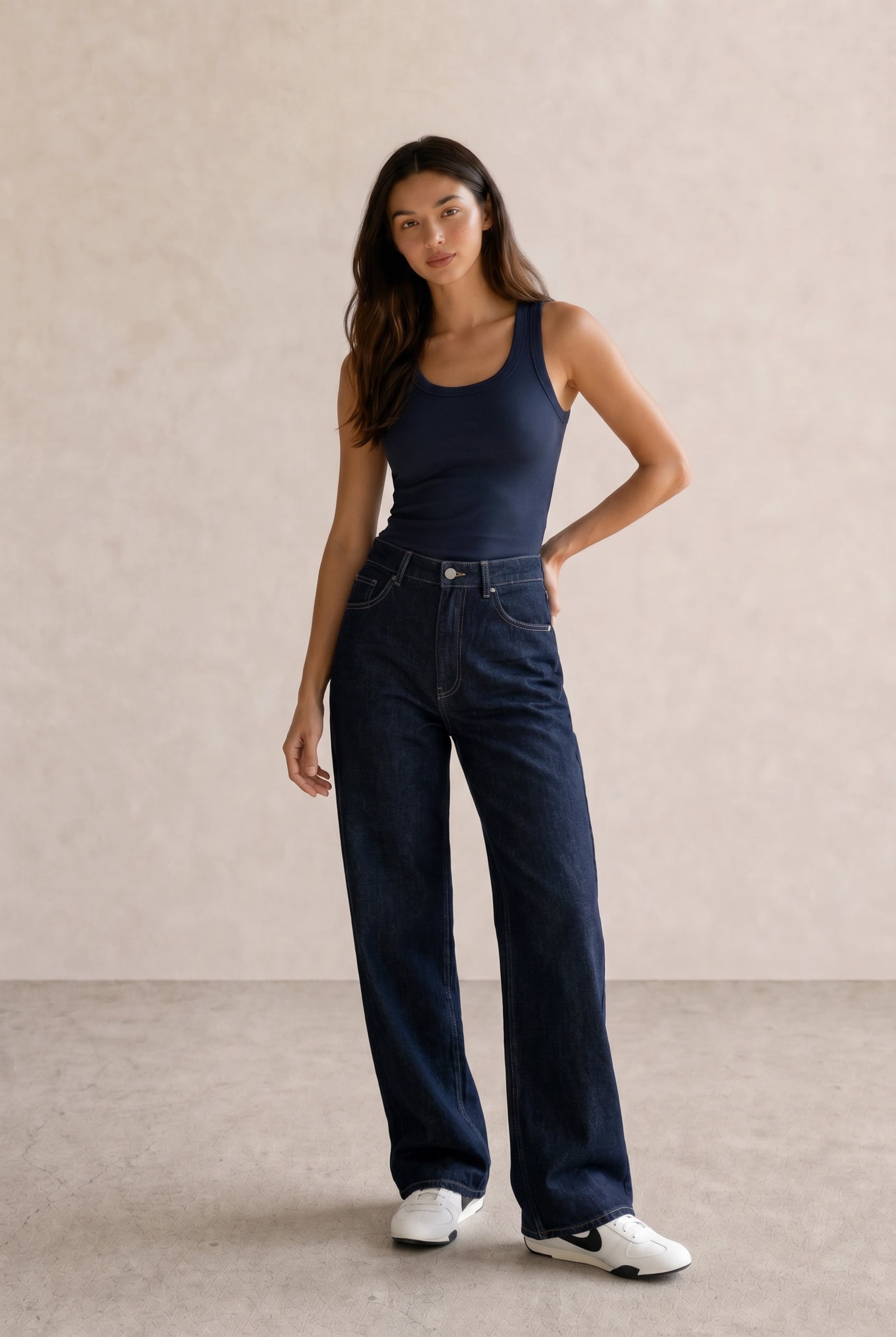 Basic casual outfit with a navy ribbed tank, dark indigo wide-leg jeans, and white Nike sneakers