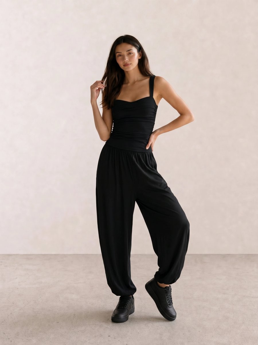 All-black outfit with a ruched corset tank top, wide parachute pants, and black sneakers
