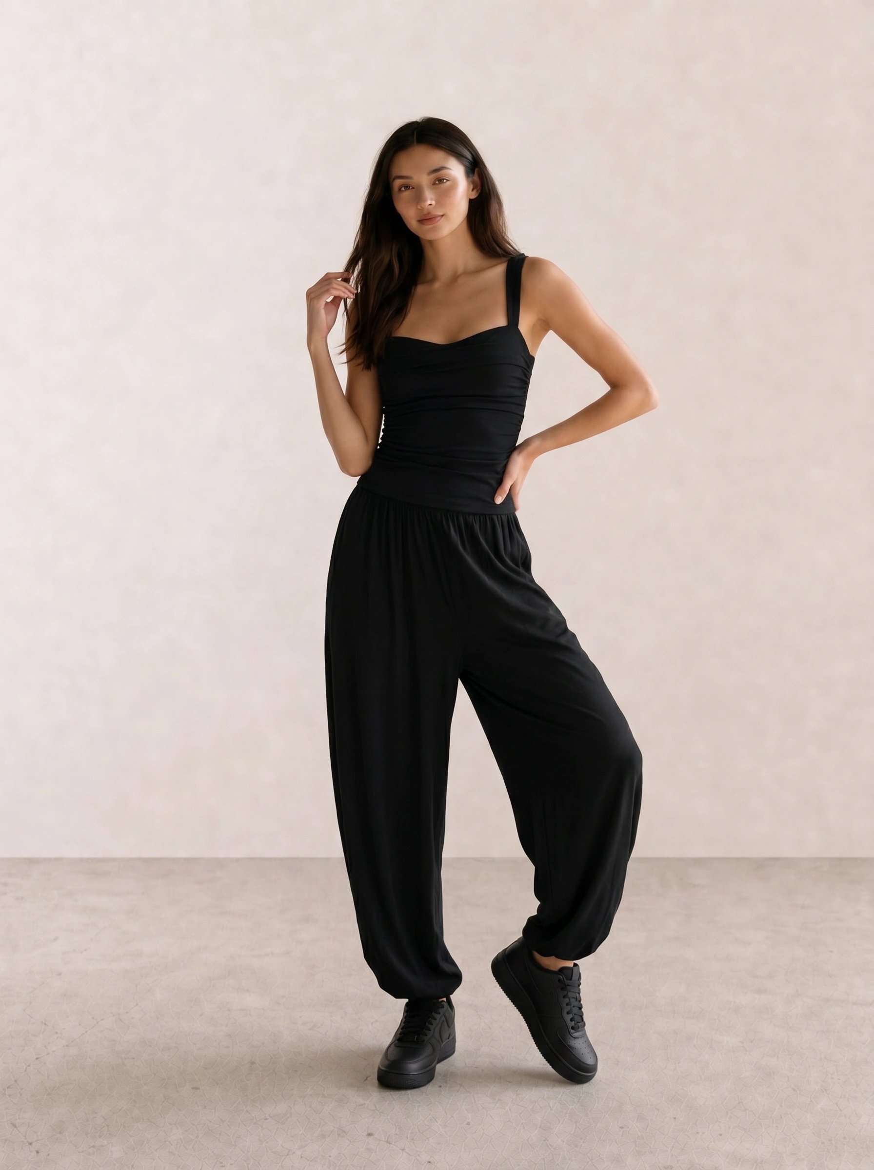 All-black outfit with a ruched corset tank top, wide parachute pants, and black sneakers
